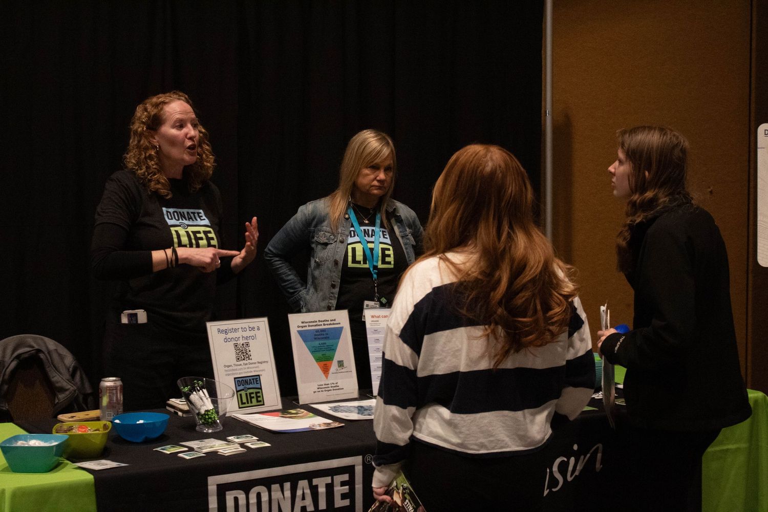 Women discussing at a Donate Life awareness table at a student leadership conference.