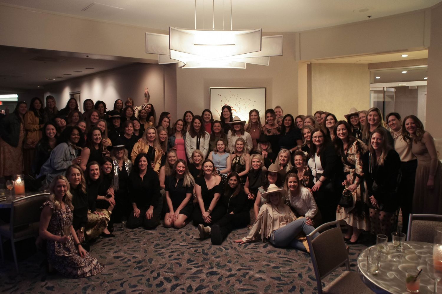 Large group of women posing together for a photo at a hotel event.