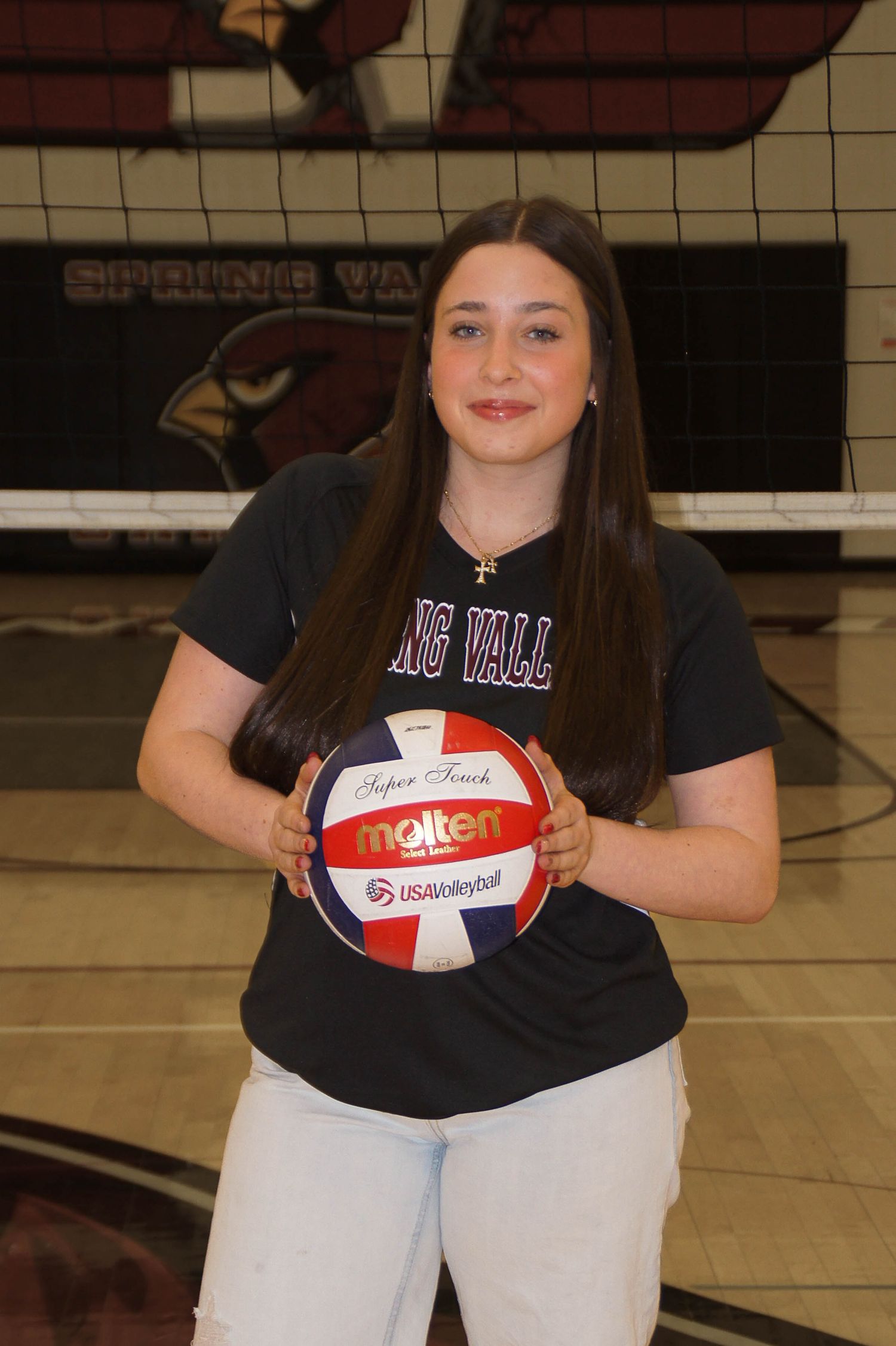Young female volleyball player holding Molten USAVolleyball in Spring Valley team shirt.