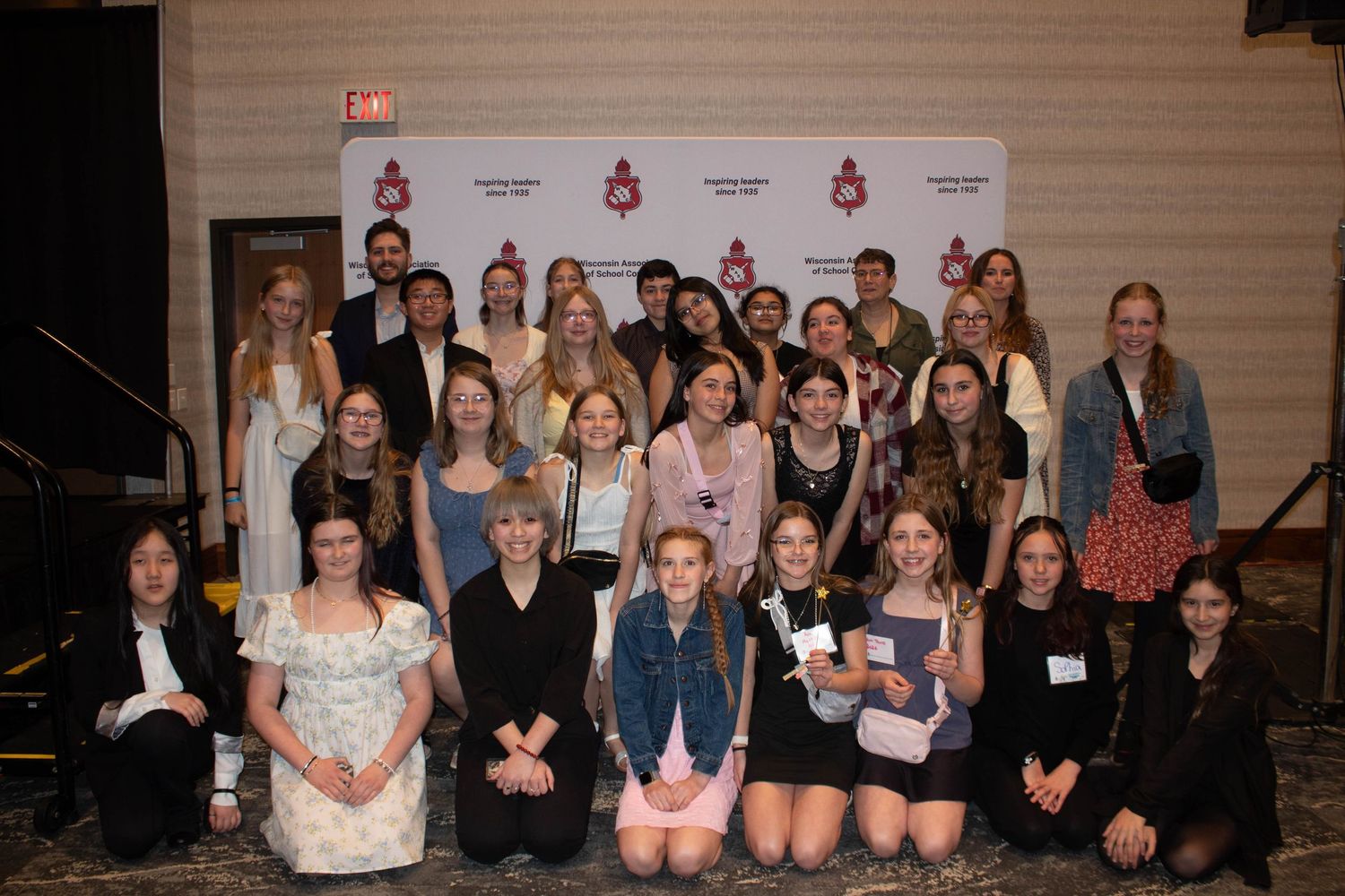 A large group of students pose together for a photo at a leadership conference.