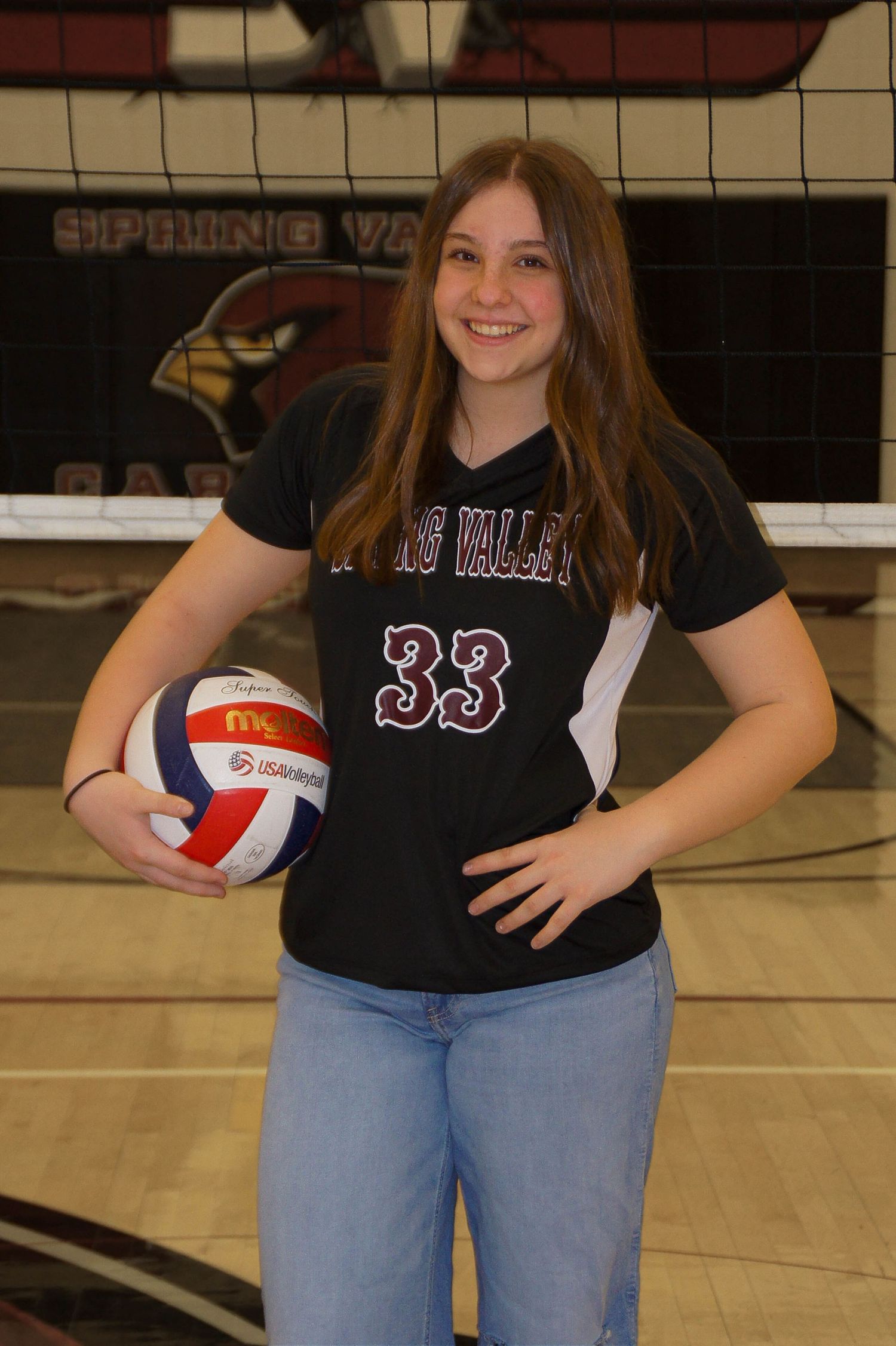 Female volleyball player in Spring Valley number 33 jersey holding ball on court.