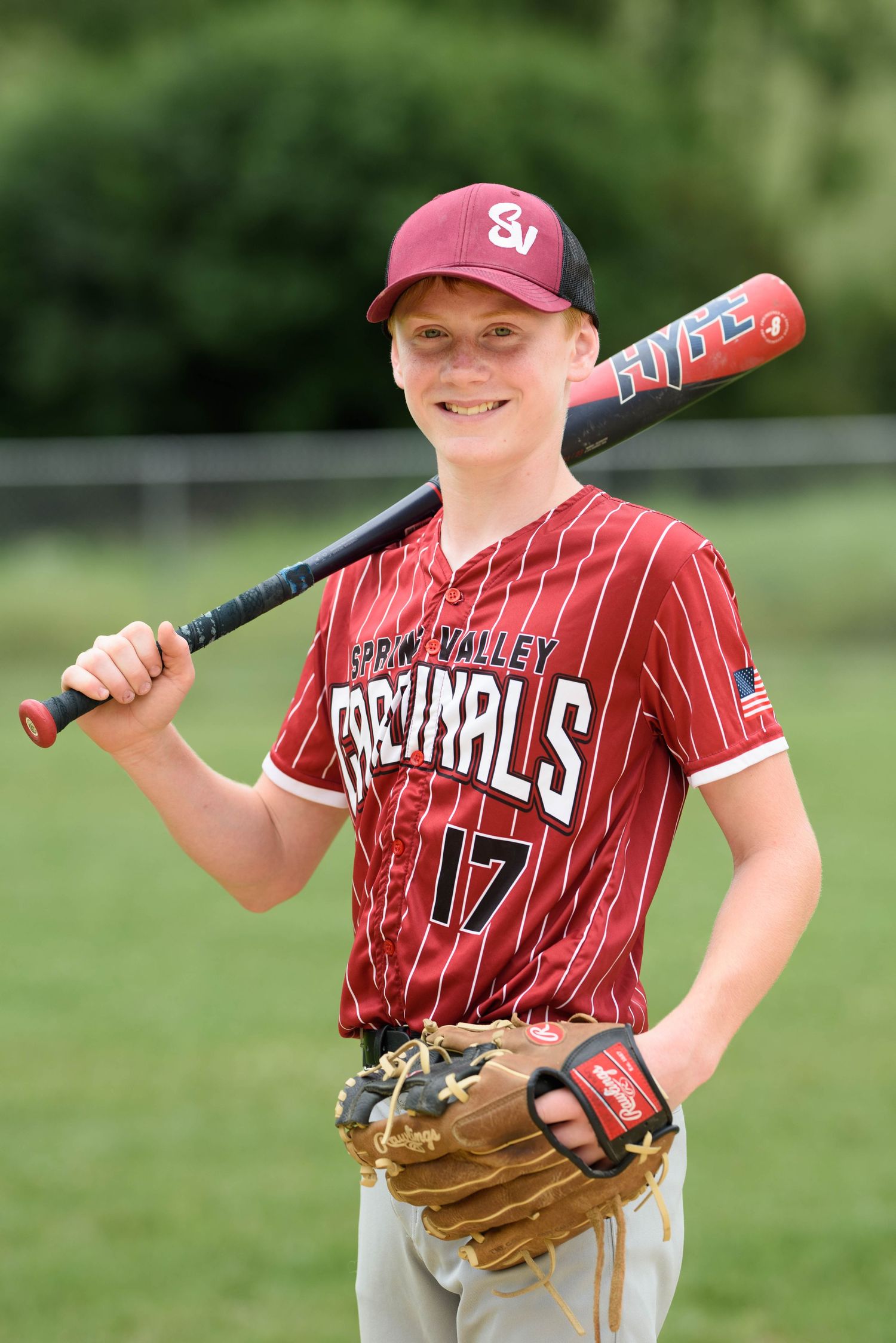 Spring Valley Cardinals baseball player #17 poses with bat and glove in red pinstripe uniform.