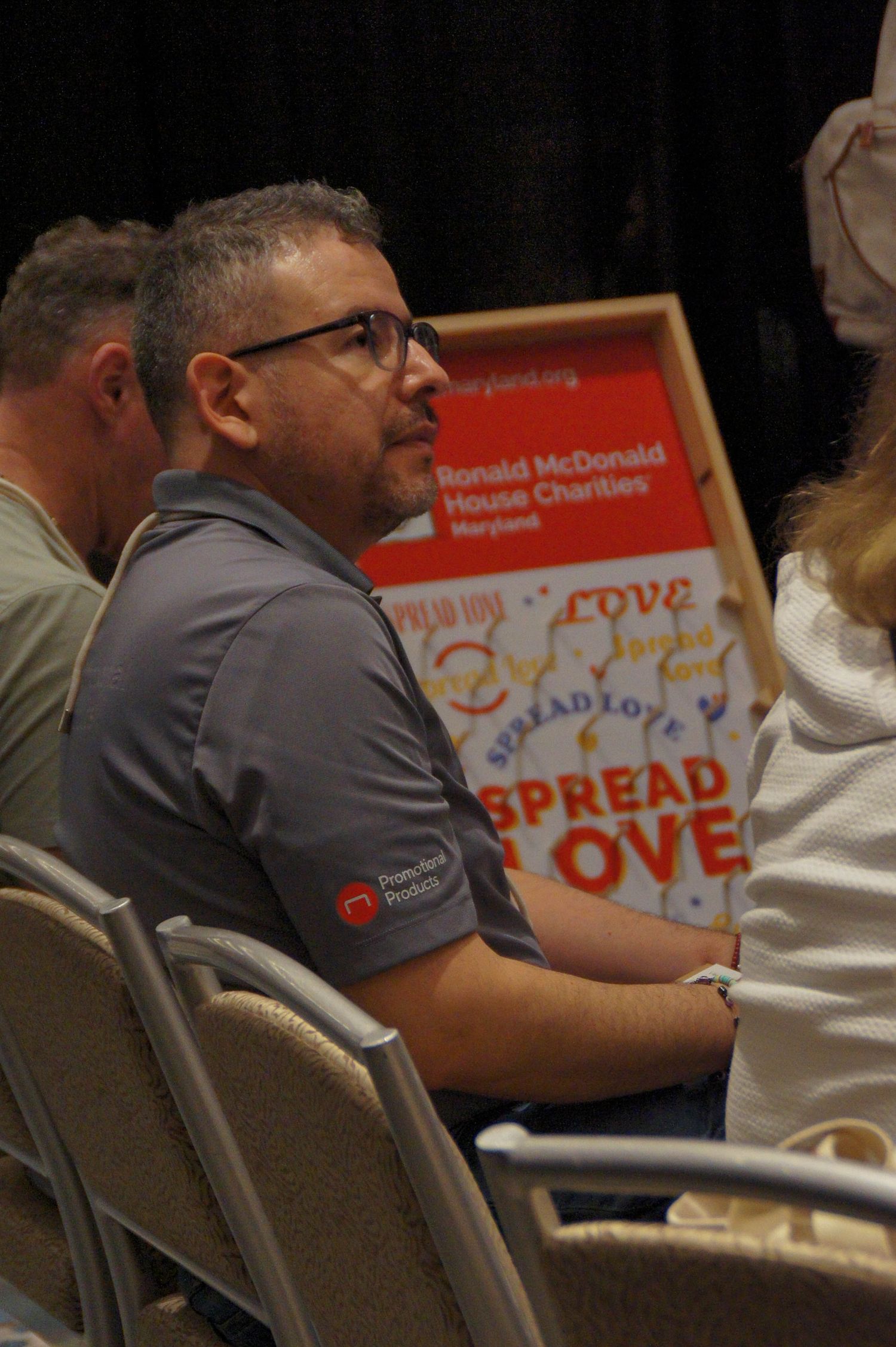 Man in gray polo shirt seated at Ronald McDonald House Charities Maryland event.