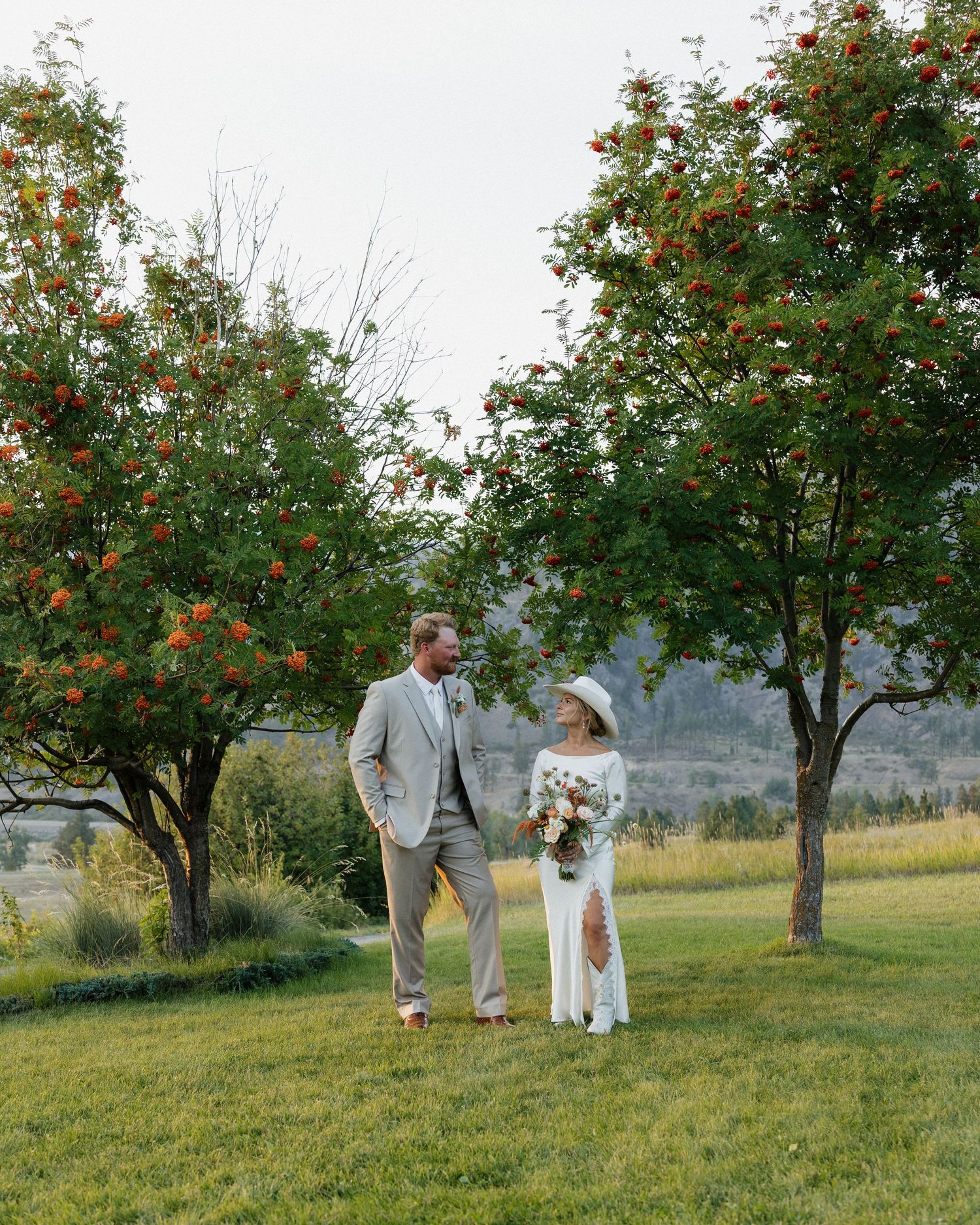 Family walking through an orchard with blooming fruit trees on a sunny day.