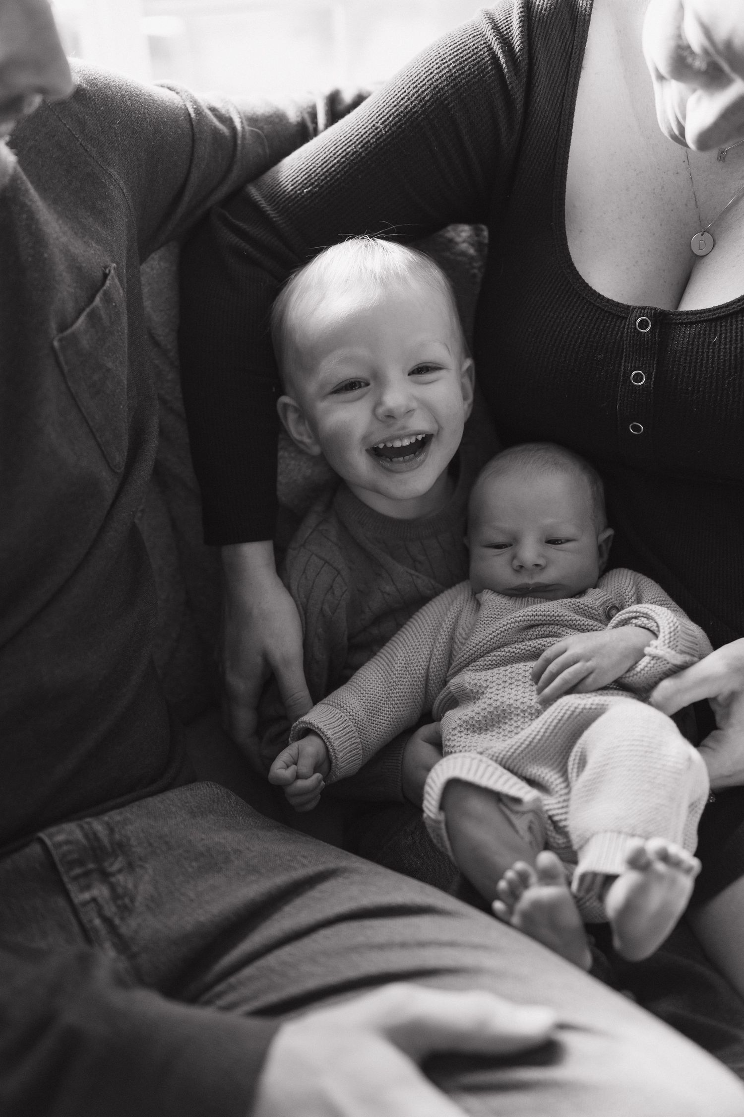 Black and white intimate family portrait on comfortable couch.