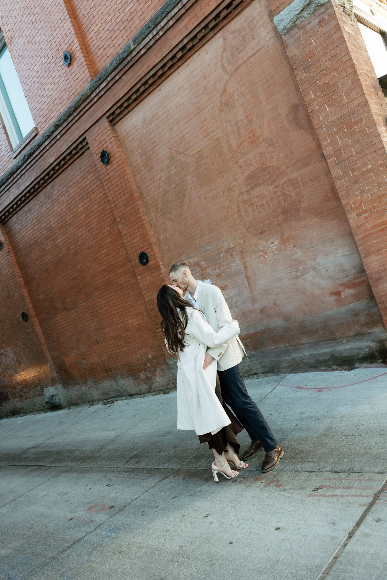 Dynamic sequence of couple dancing against brick wall with dramatic angles.
