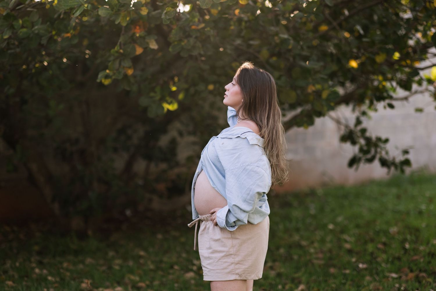 Person in casual attire walking through a garden setting.