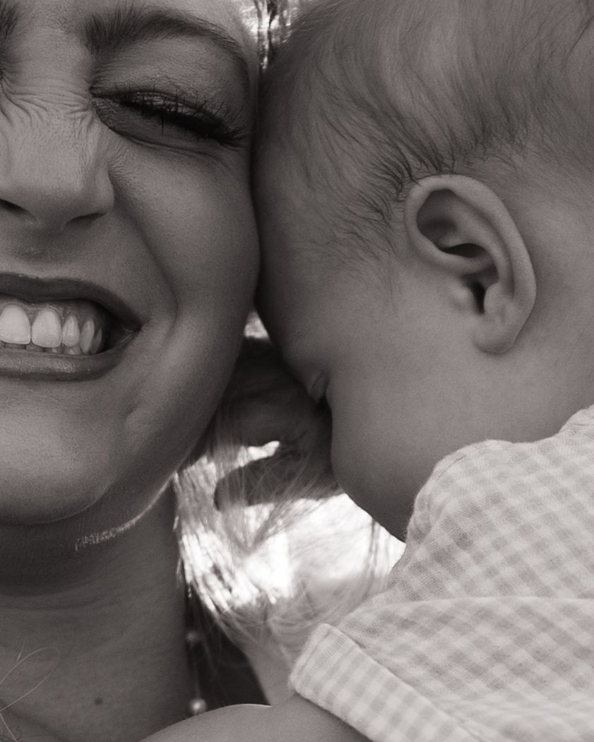 Intimate black and white close-up portrait showing tender moment between parent and baby.