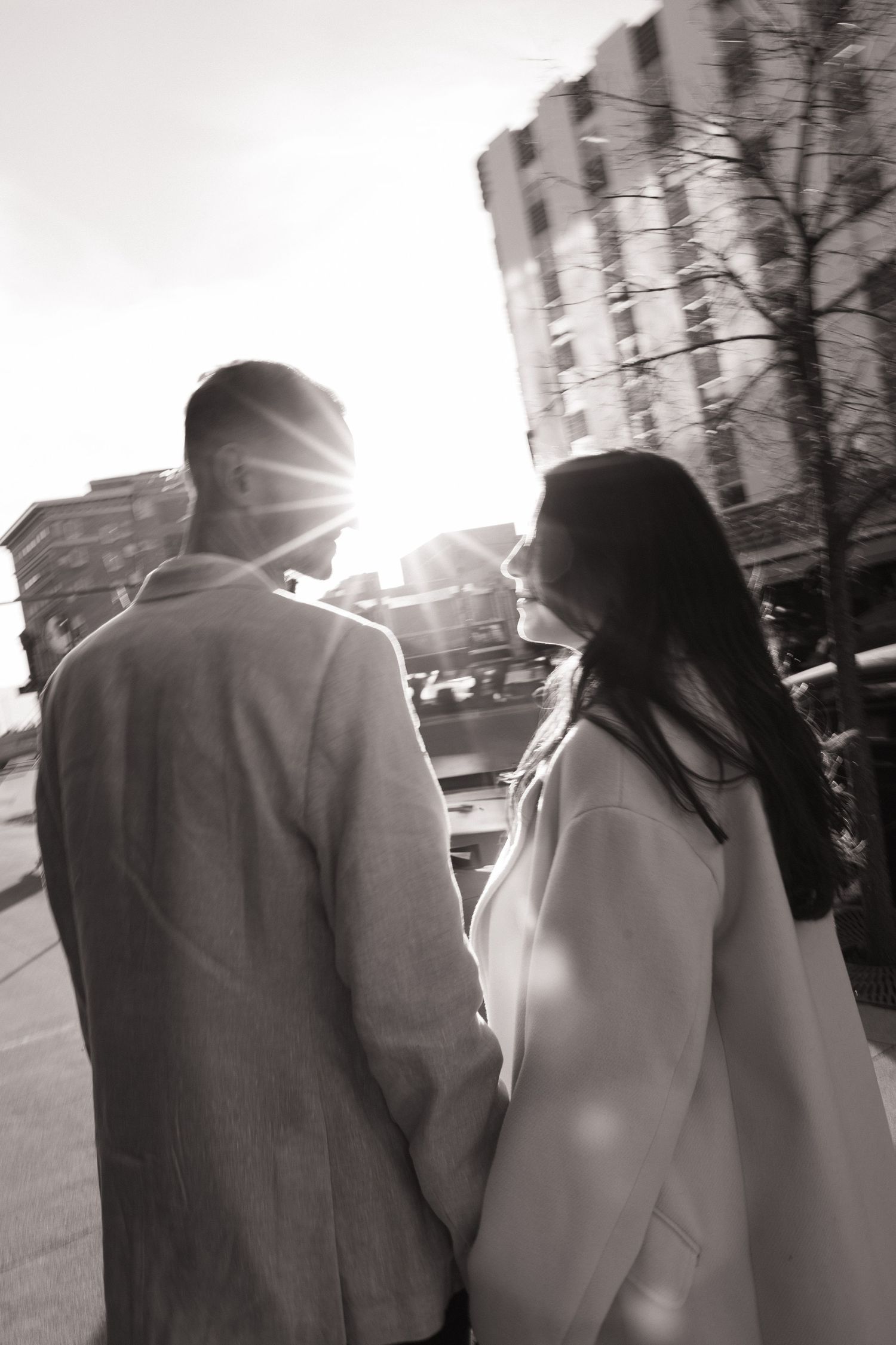 A couple walking together on a city street in black and white.