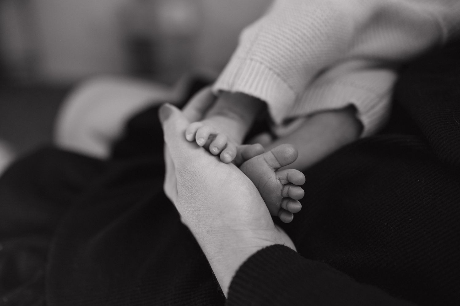 Interlocked hands showing intimacy and connection in black and white photography.
