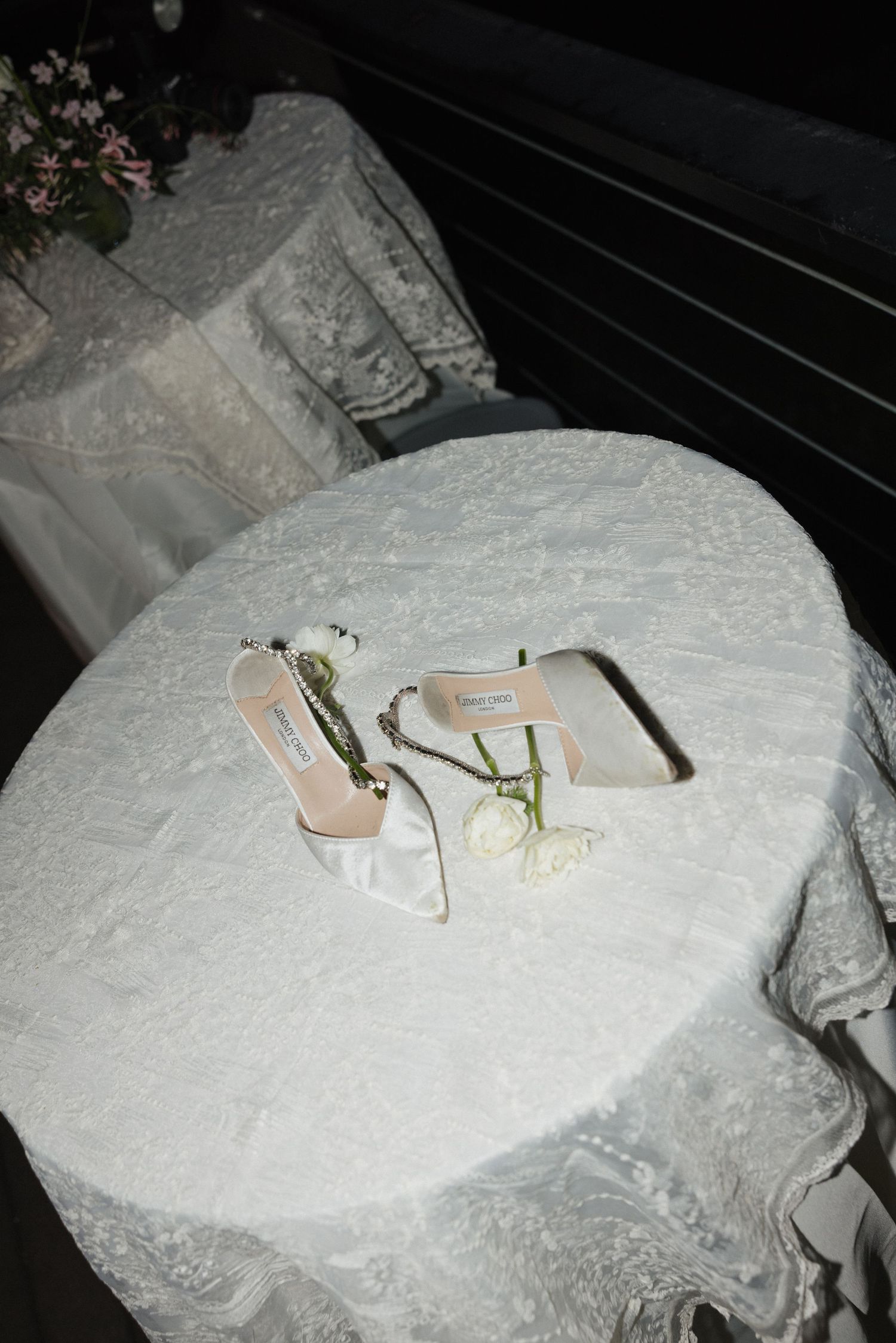 Wedding rings and jewelry displayed on delicate white lace fabric.