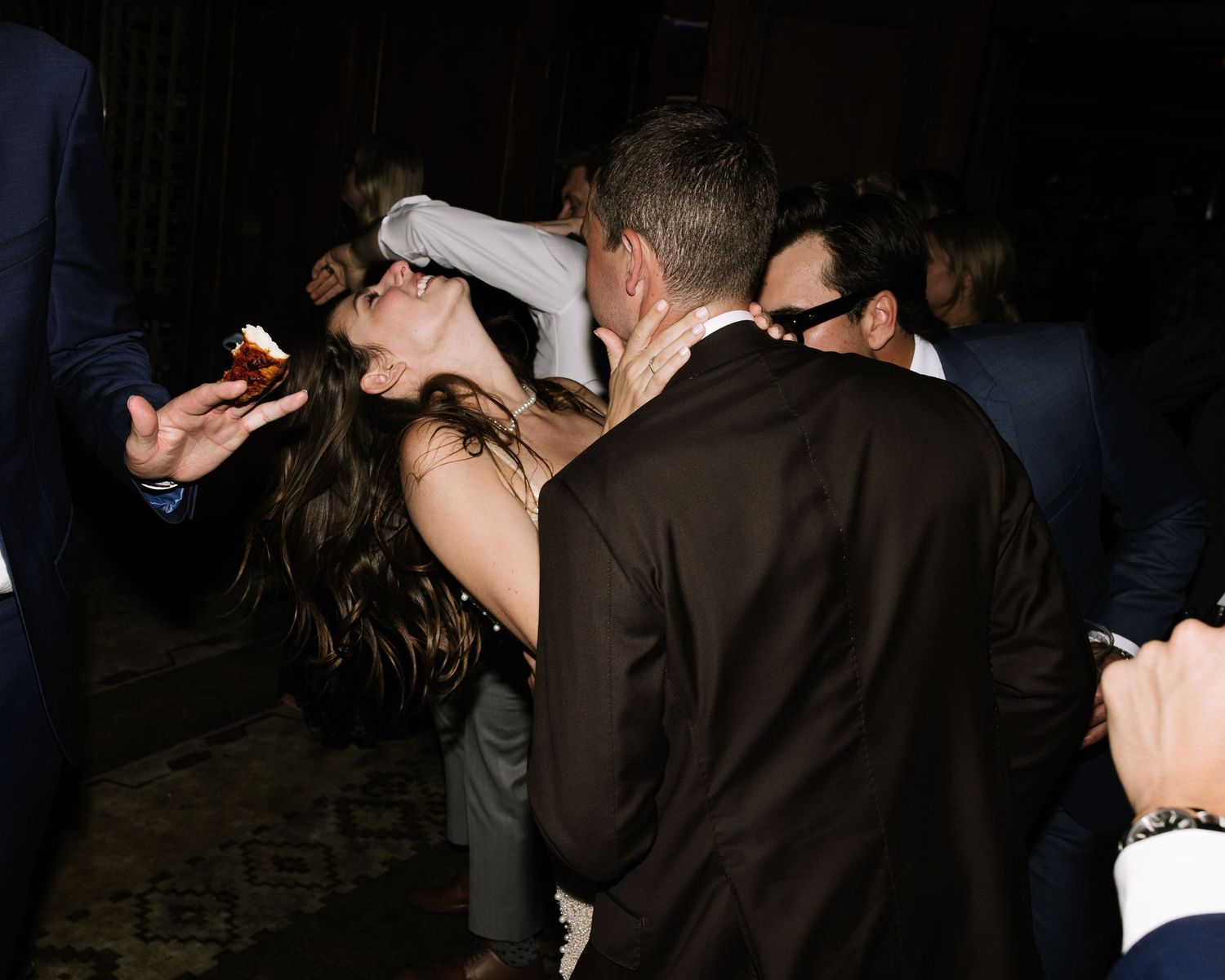 Dark silhouettes of people dancing at a nighttime event.