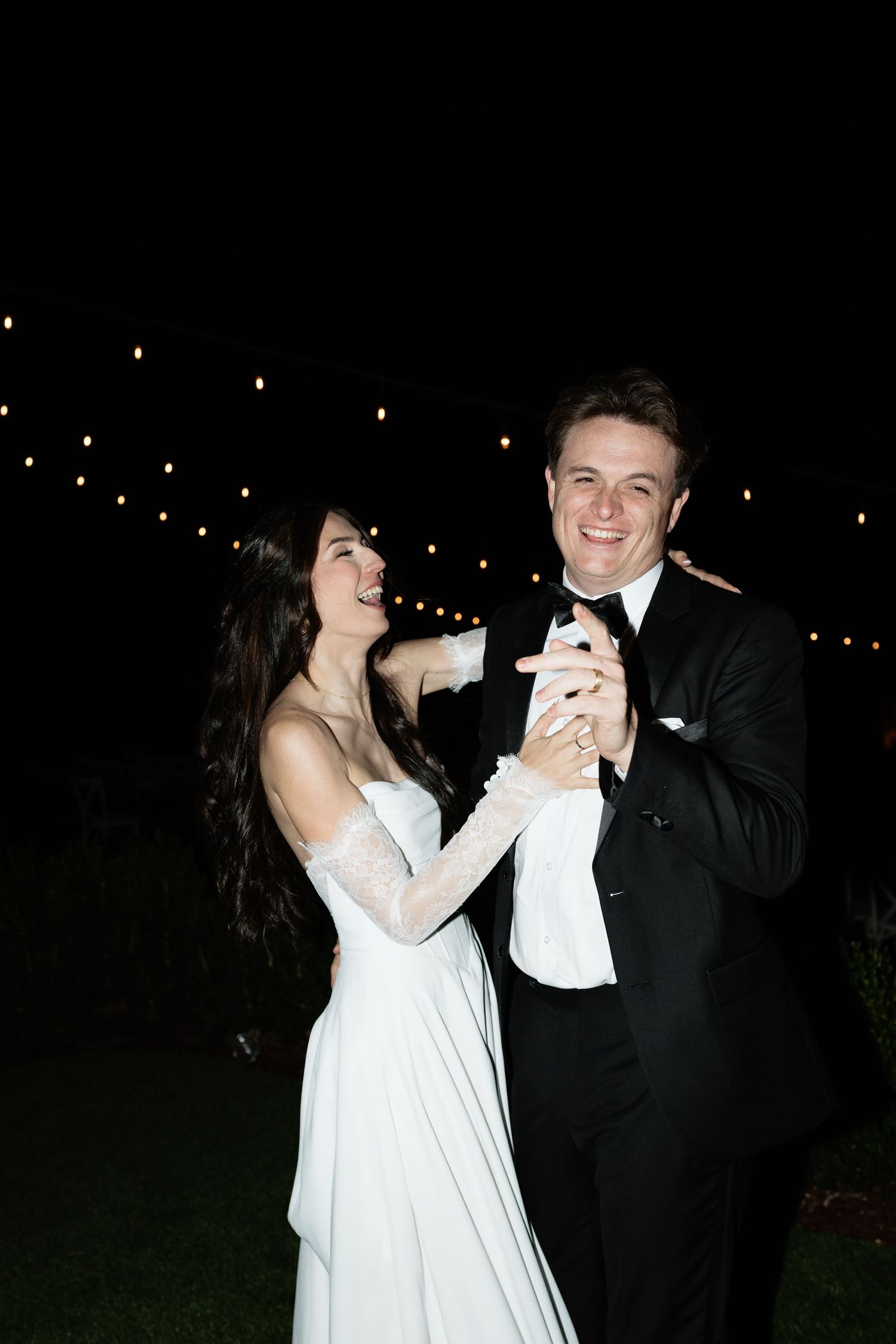 Evening wedding celebration with string lights creating a magical atmosphere.