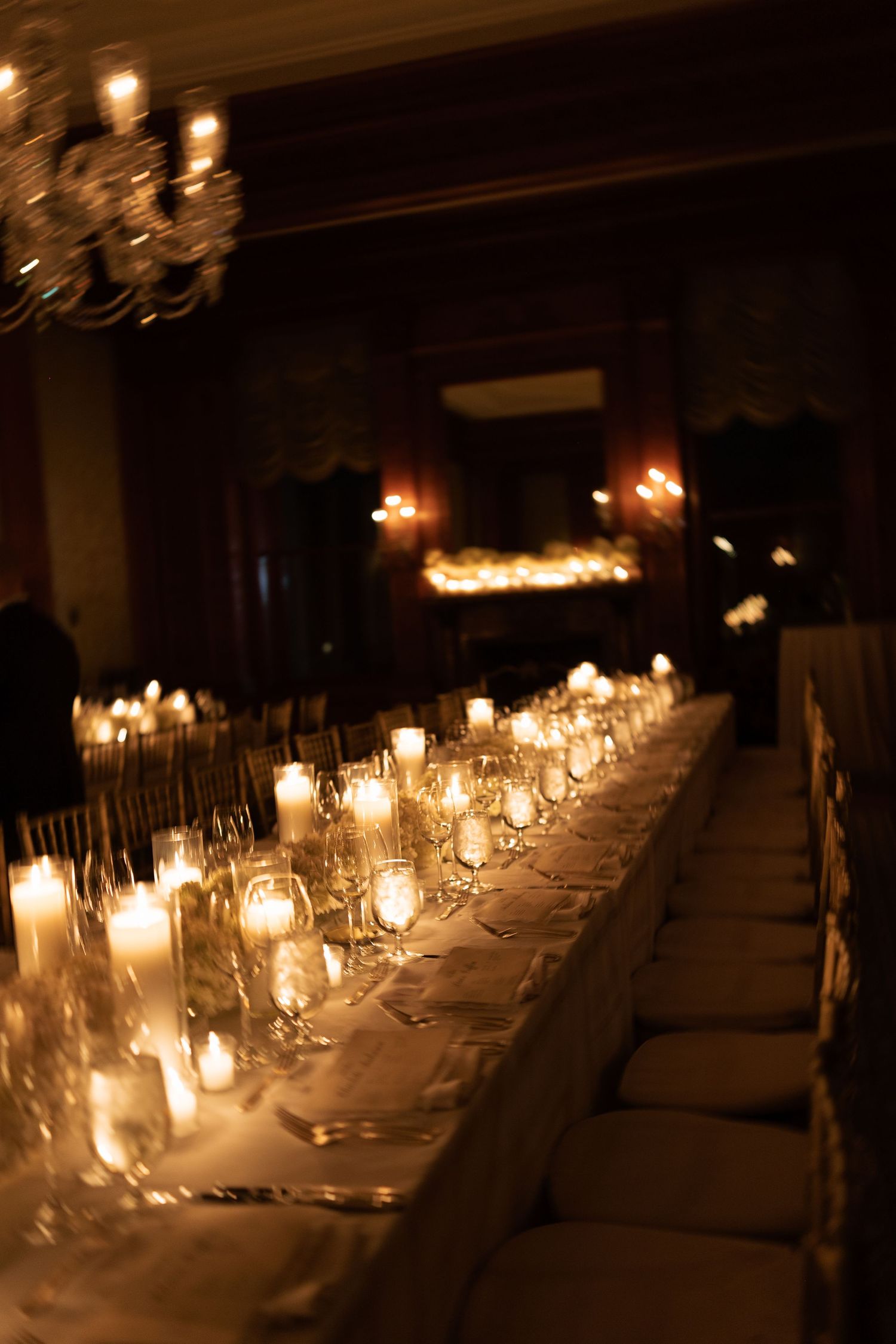 Elegant table setting with glowing candles and crystal glasses creating romantic ambiance.