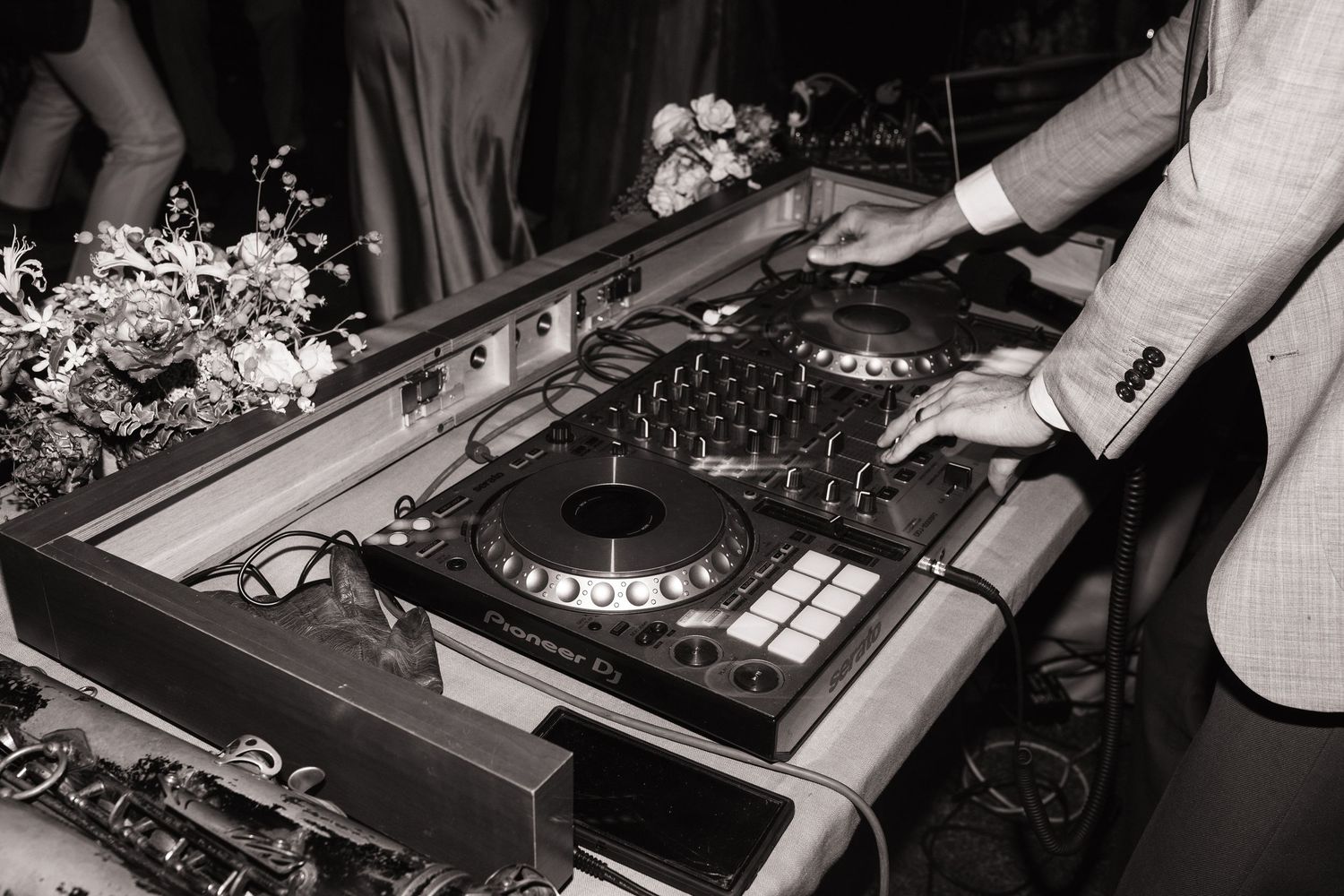 DJ equipment and mixer setup in black and white at event.