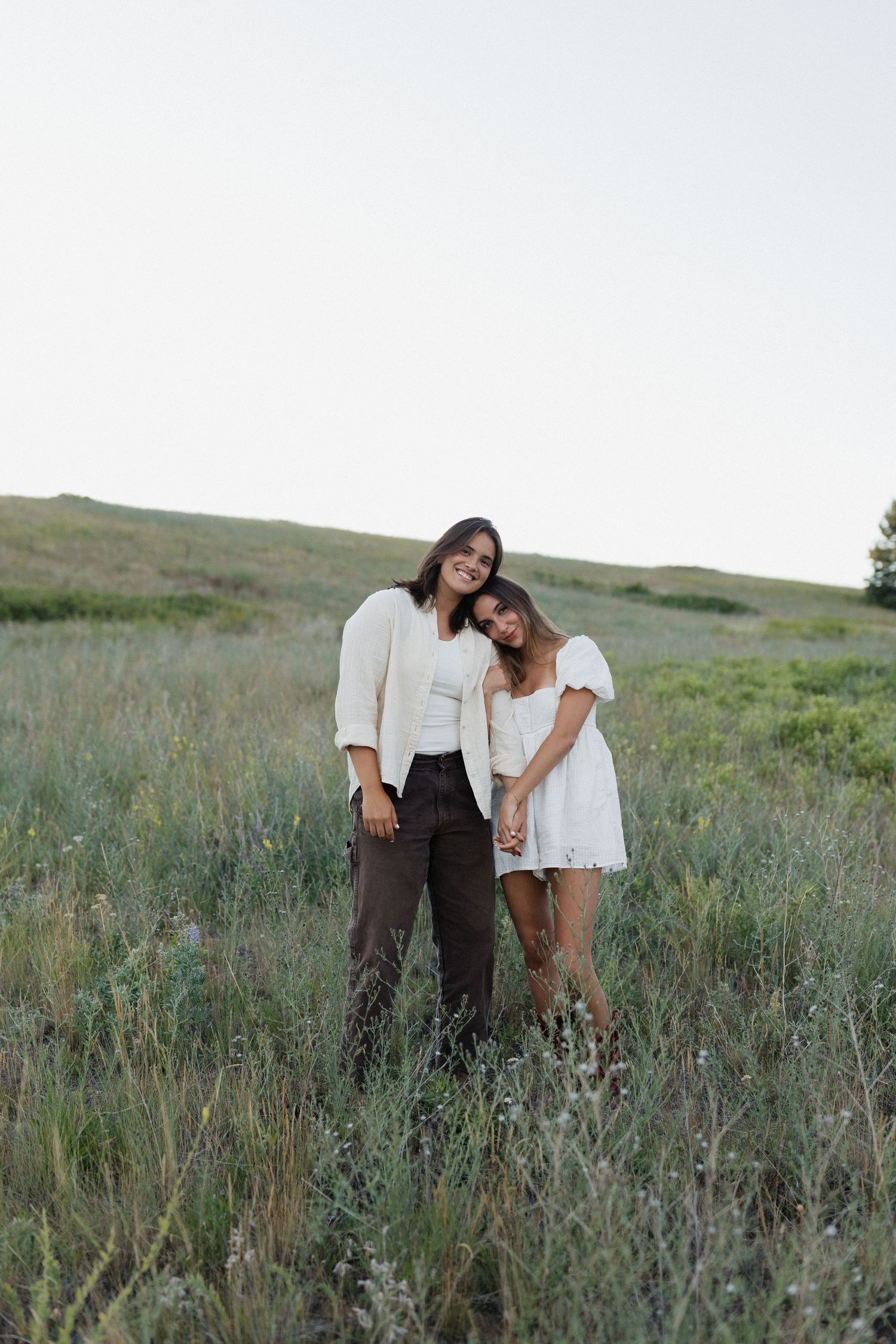 Couple sharing tender moments in a green summer meadow.