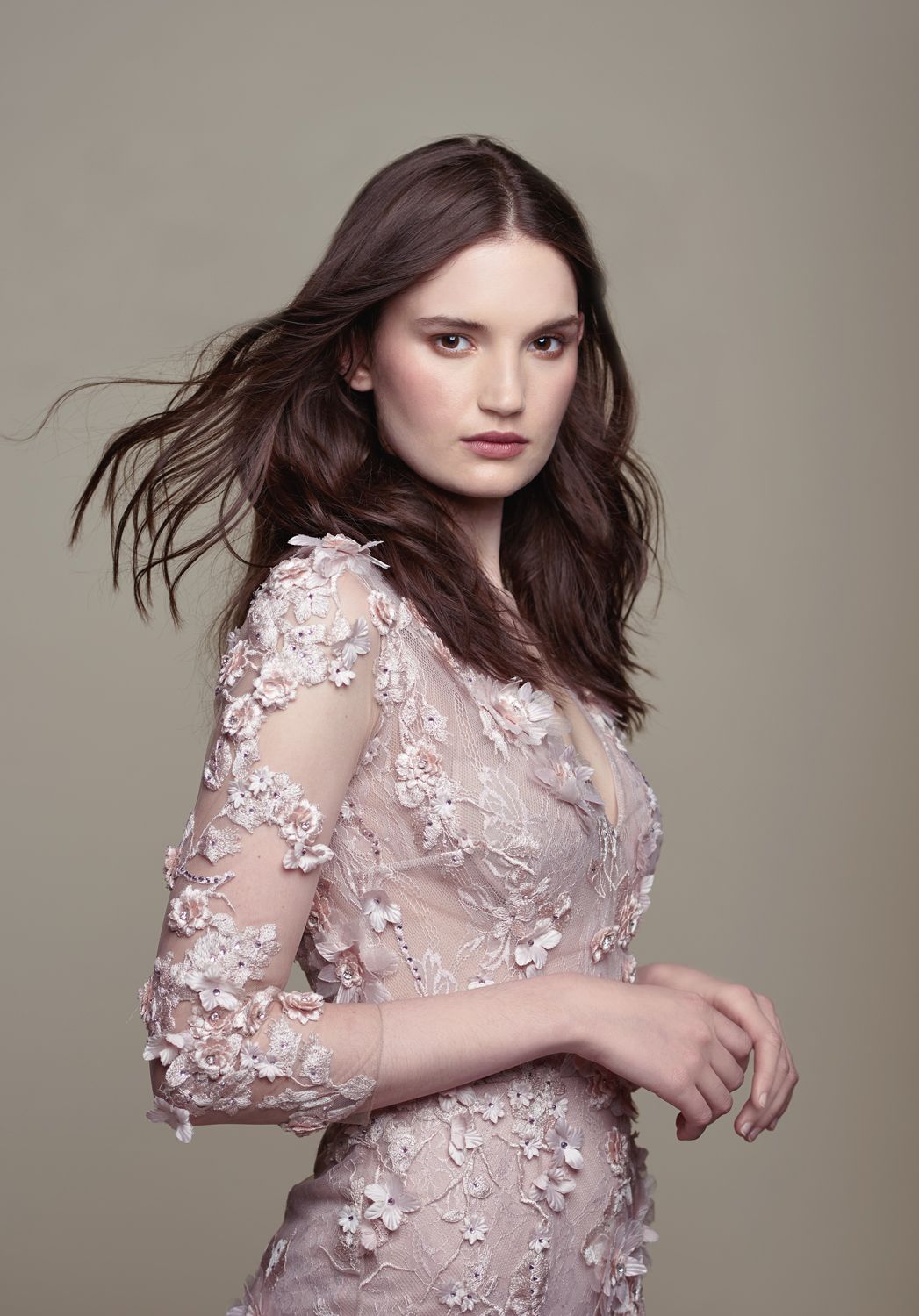 Photo of a Woman taken by Jr Francisco Photography wearing a blush pink floral lace gown with 3/4 sleeves and delicate 3D floral appliques.