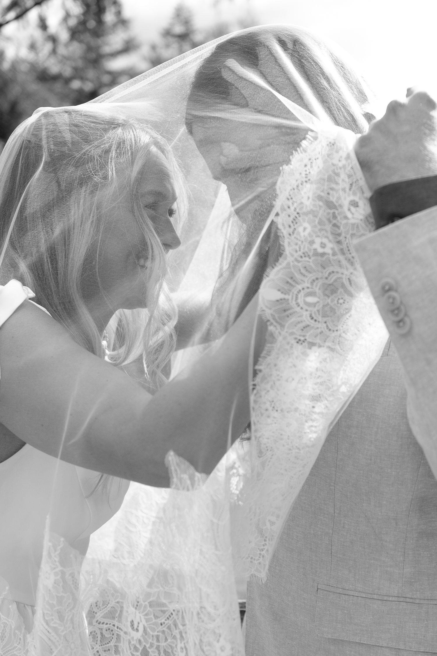 Black and white intimate elopement first look moment under bridal veil