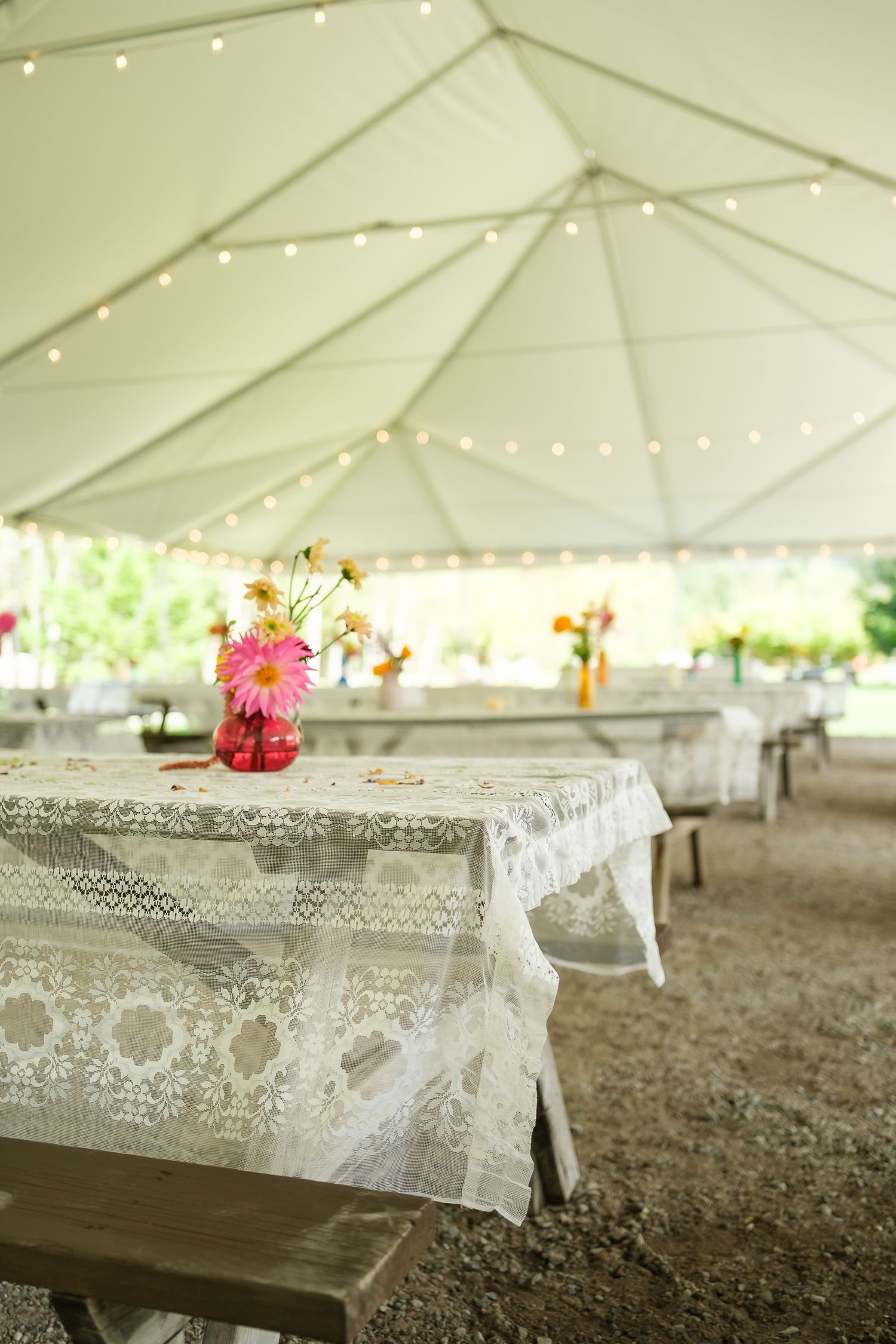 Outdoor marquee reception setup with lace table runners for rustic ranch wedding