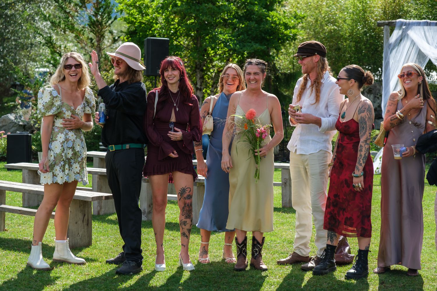 Candid wedding guests laughing outdoors during rustic ranch celebration