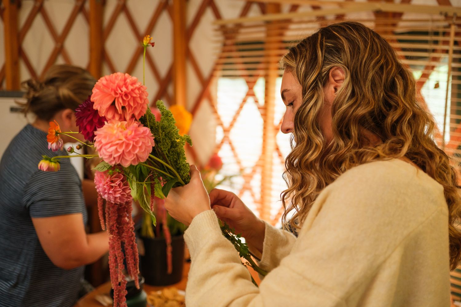 Candid prep photography of florist arranging dahlias for Cheeky Ranch wedding