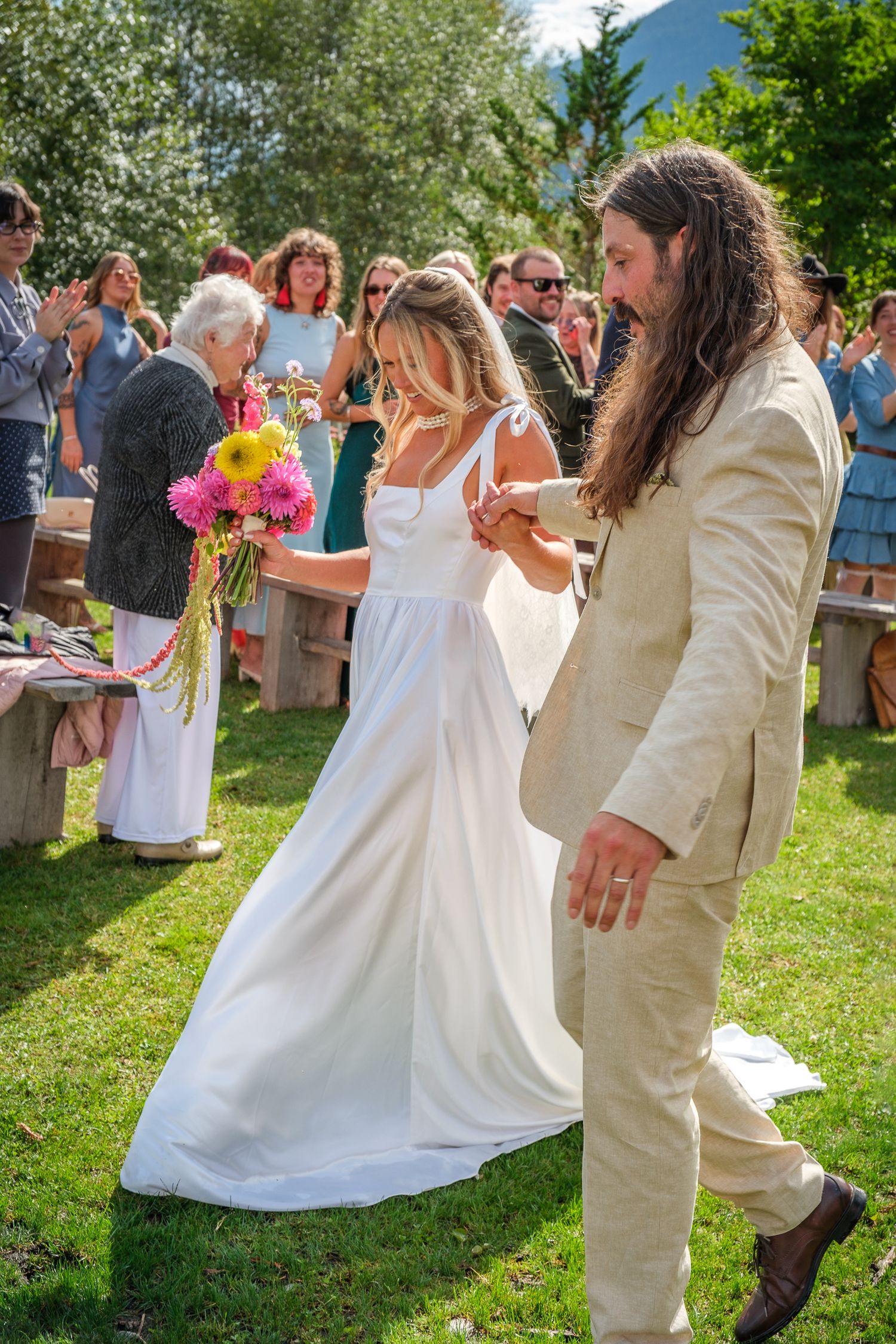 Candid bride and groom recessional walk outdoors after wedding ceremony