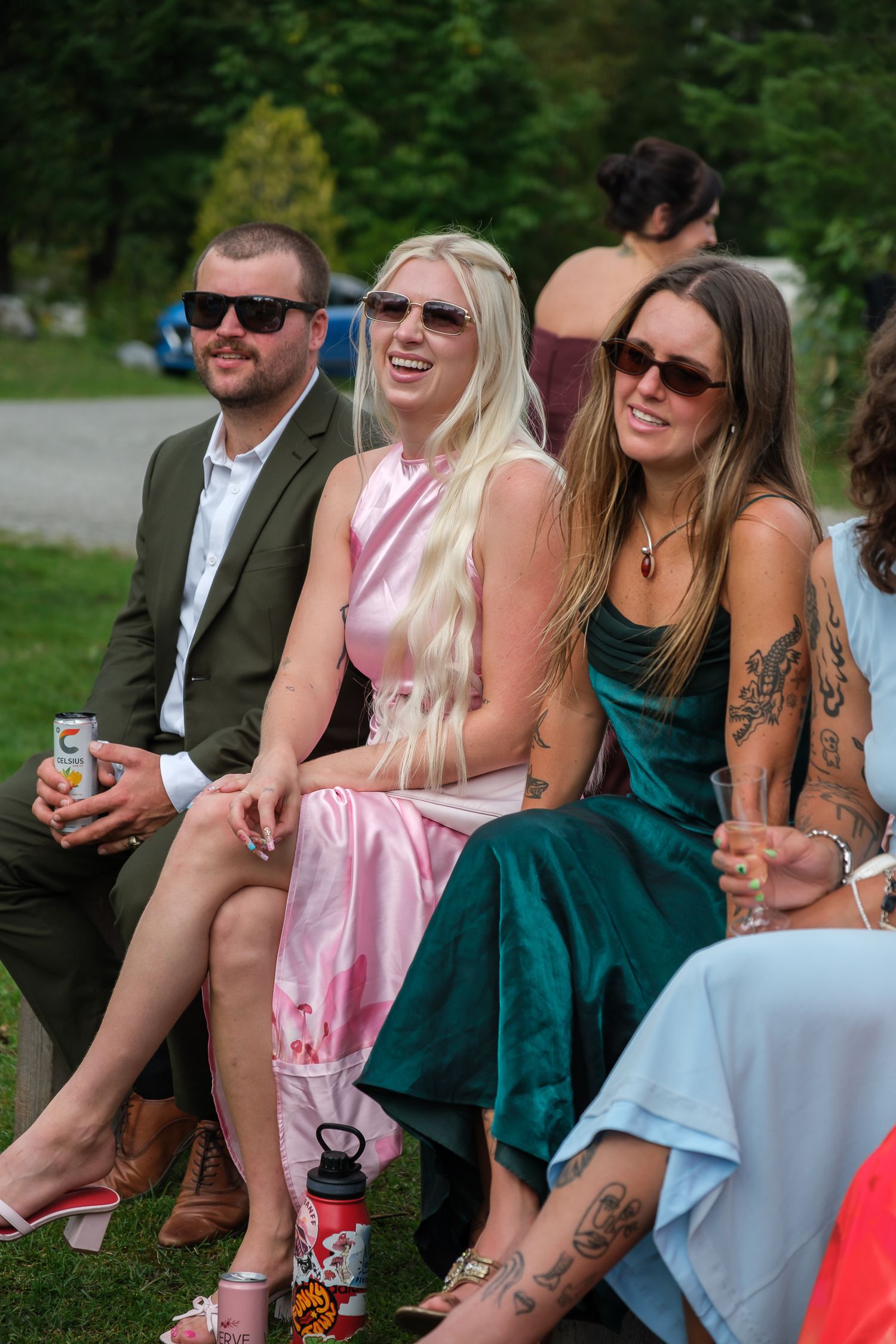 Candid wedding guests sitting outdoors during rustic ranch celebration