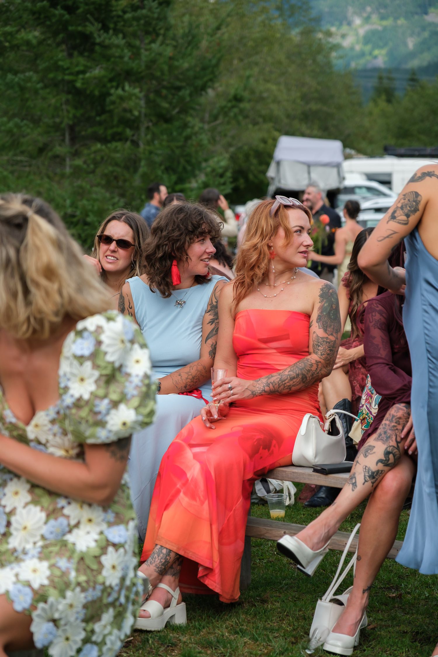 Candid wedding guests sitting outdoors during rustic ranch celebration