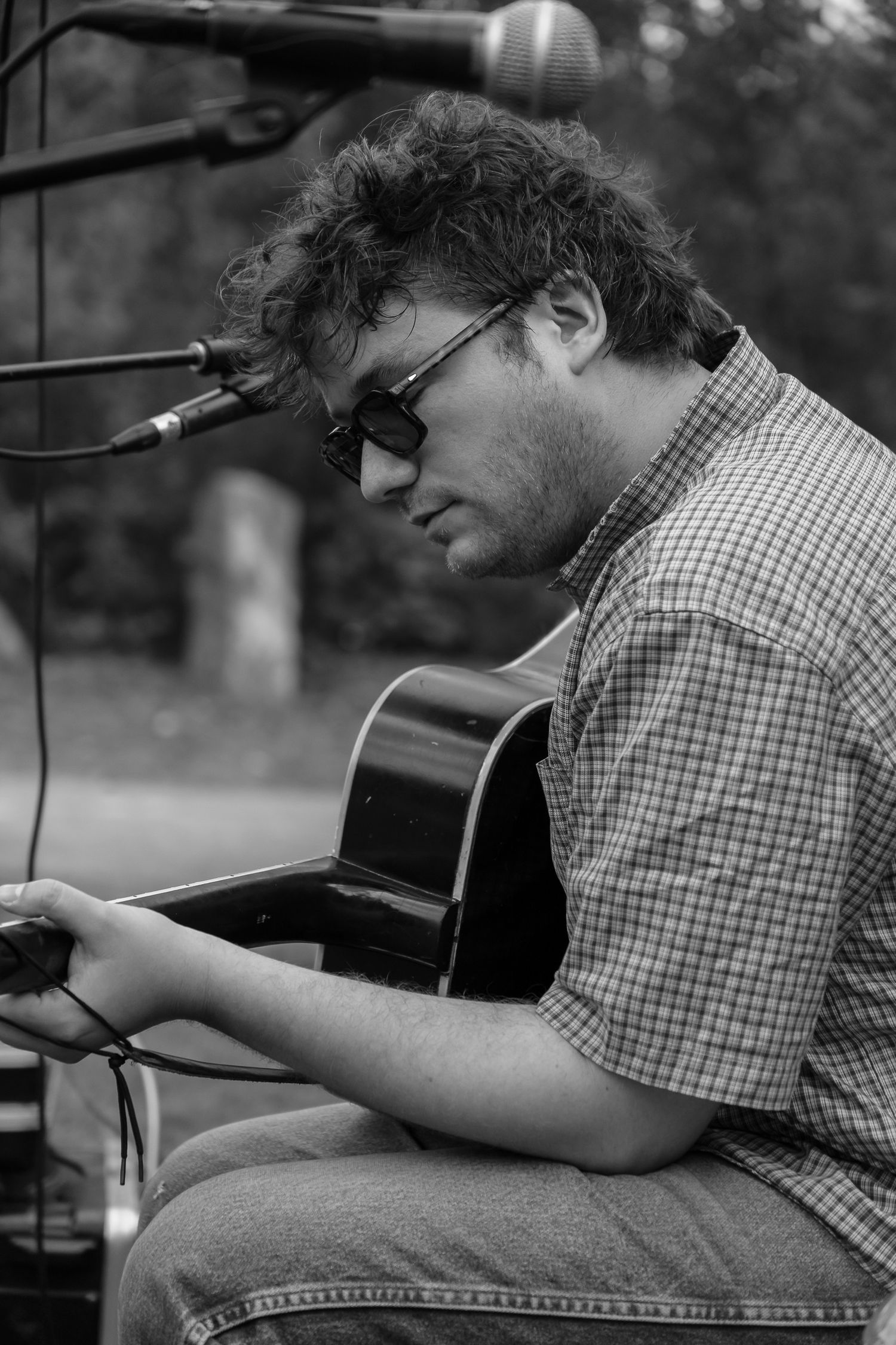 Black and white candid shot of live acoustic musician playing guitar at wedding