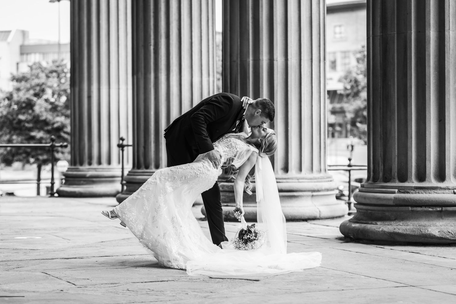 A newly married couple kisses in front of the pillars  at St George's Hall, Liverpool.