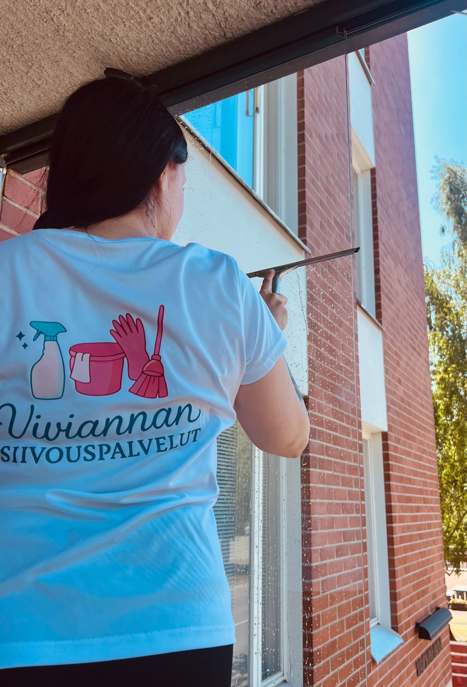 Ikkunanpesu, siivooja pesemässä parvekelaseja