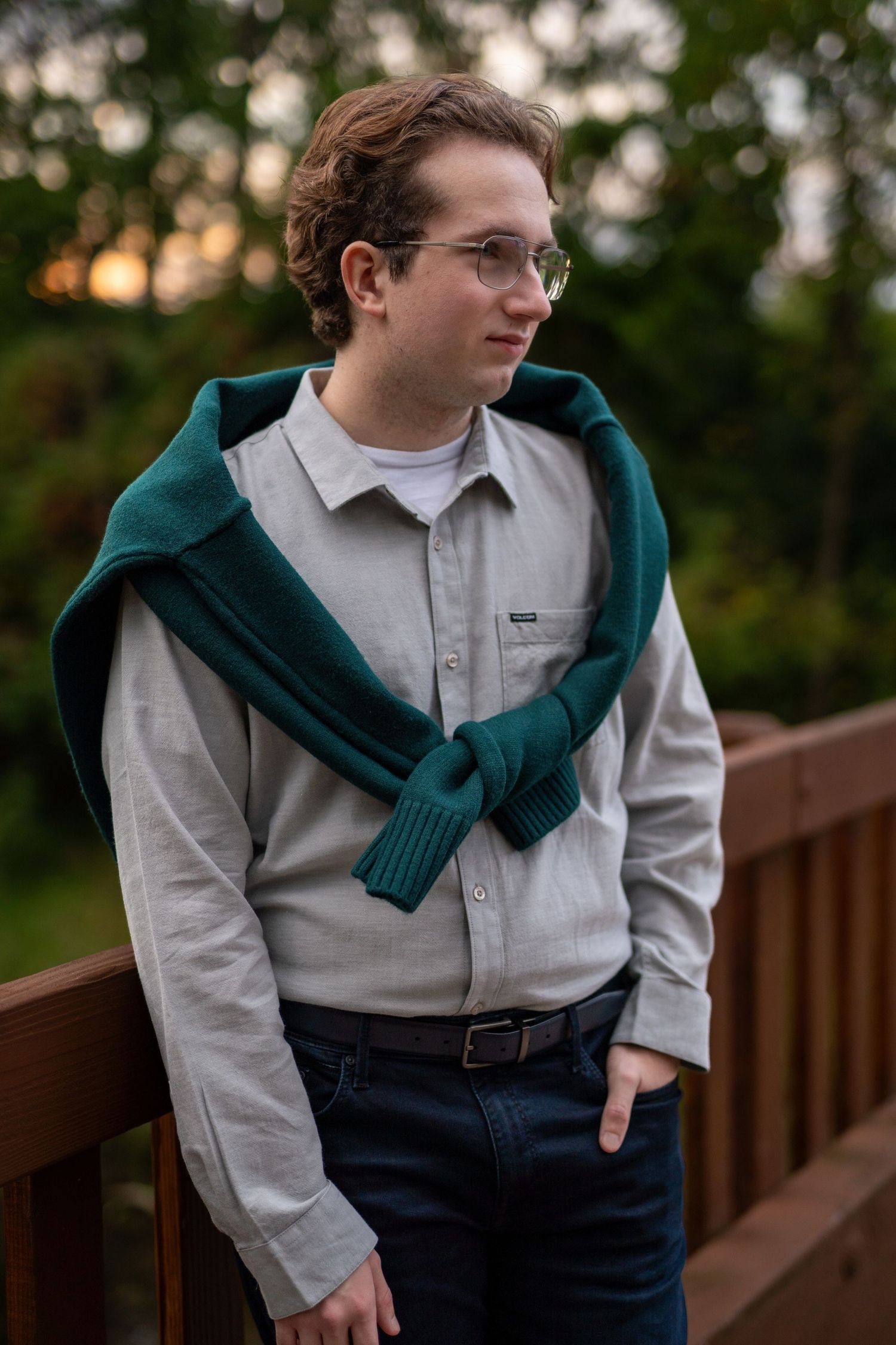 Male Senior Portrait with green sweater tied on shoulders, good lighting