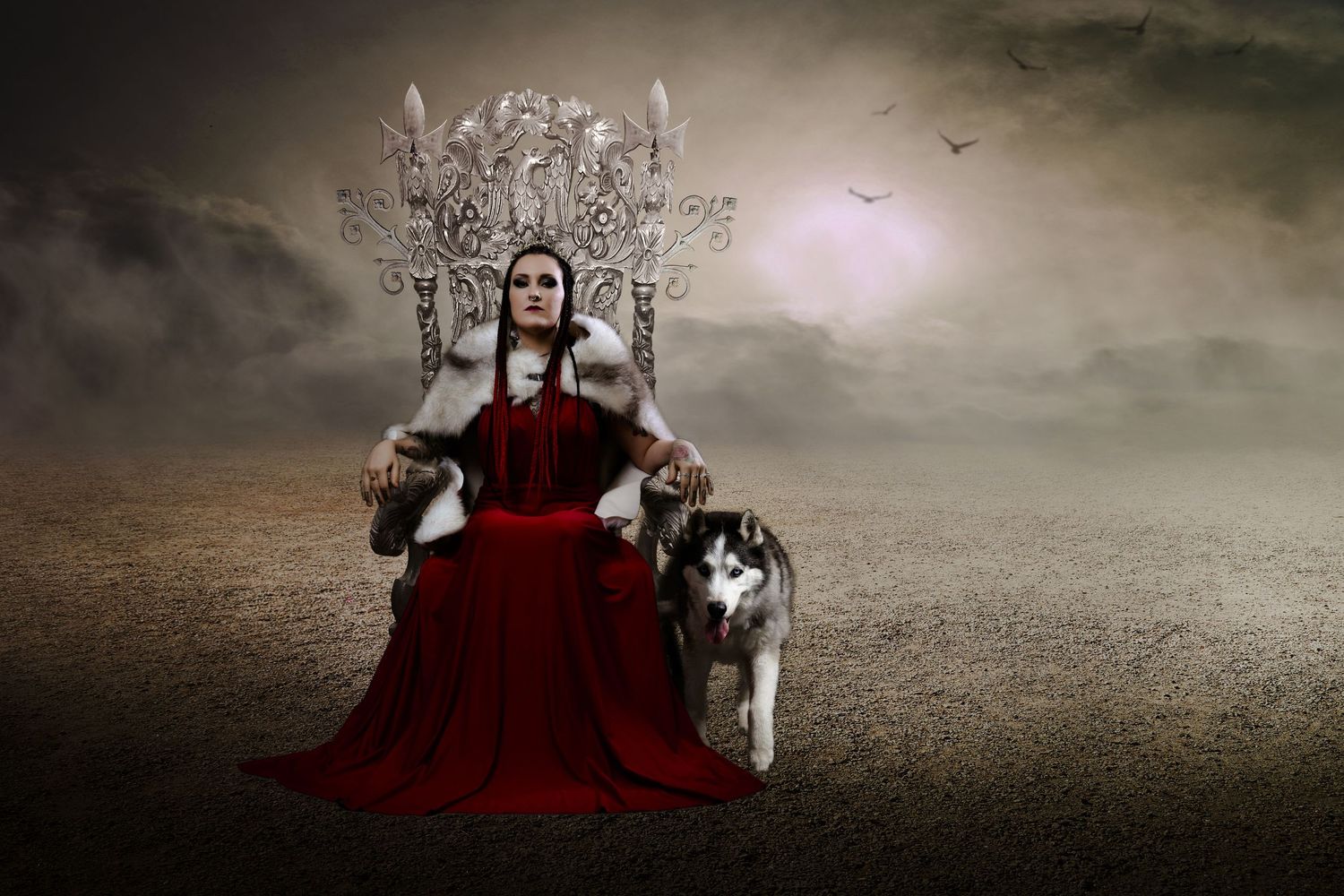 Regal woman in red gown sits on ornate throne with husky dog in misty desert scene.