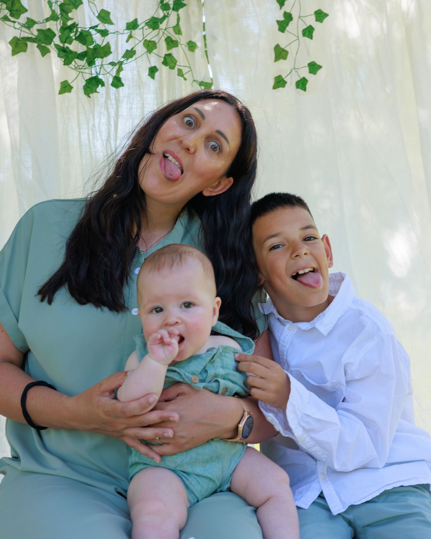 Une maman fait de drôles de têtes avec ses enfants pendant une séance photo famille.