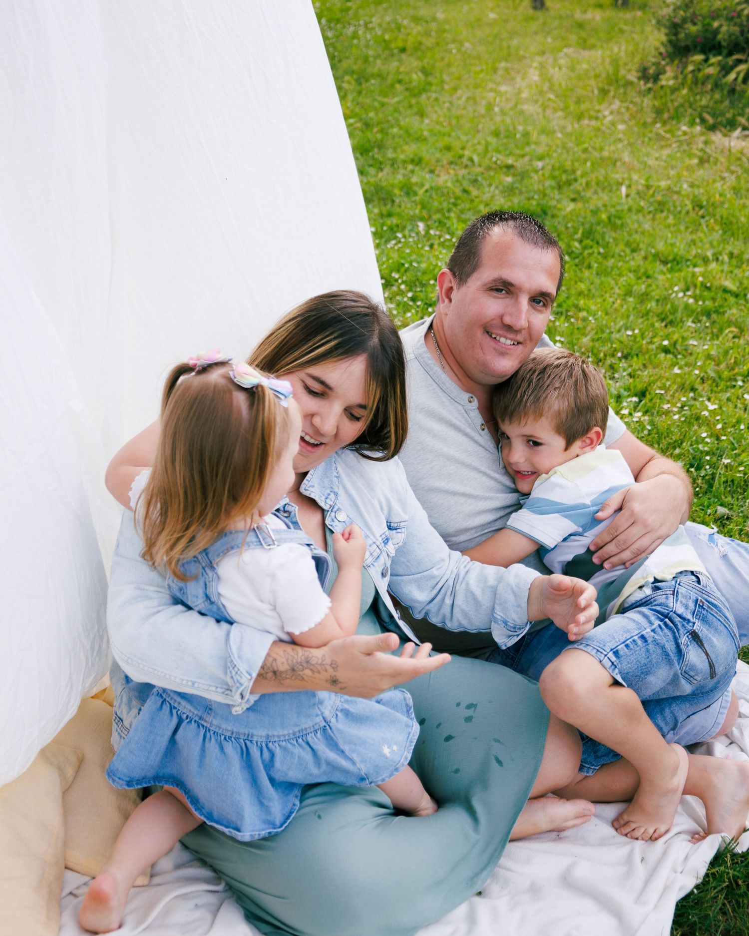 Une famille joue ensemble  pendant une séance photo famille au parc