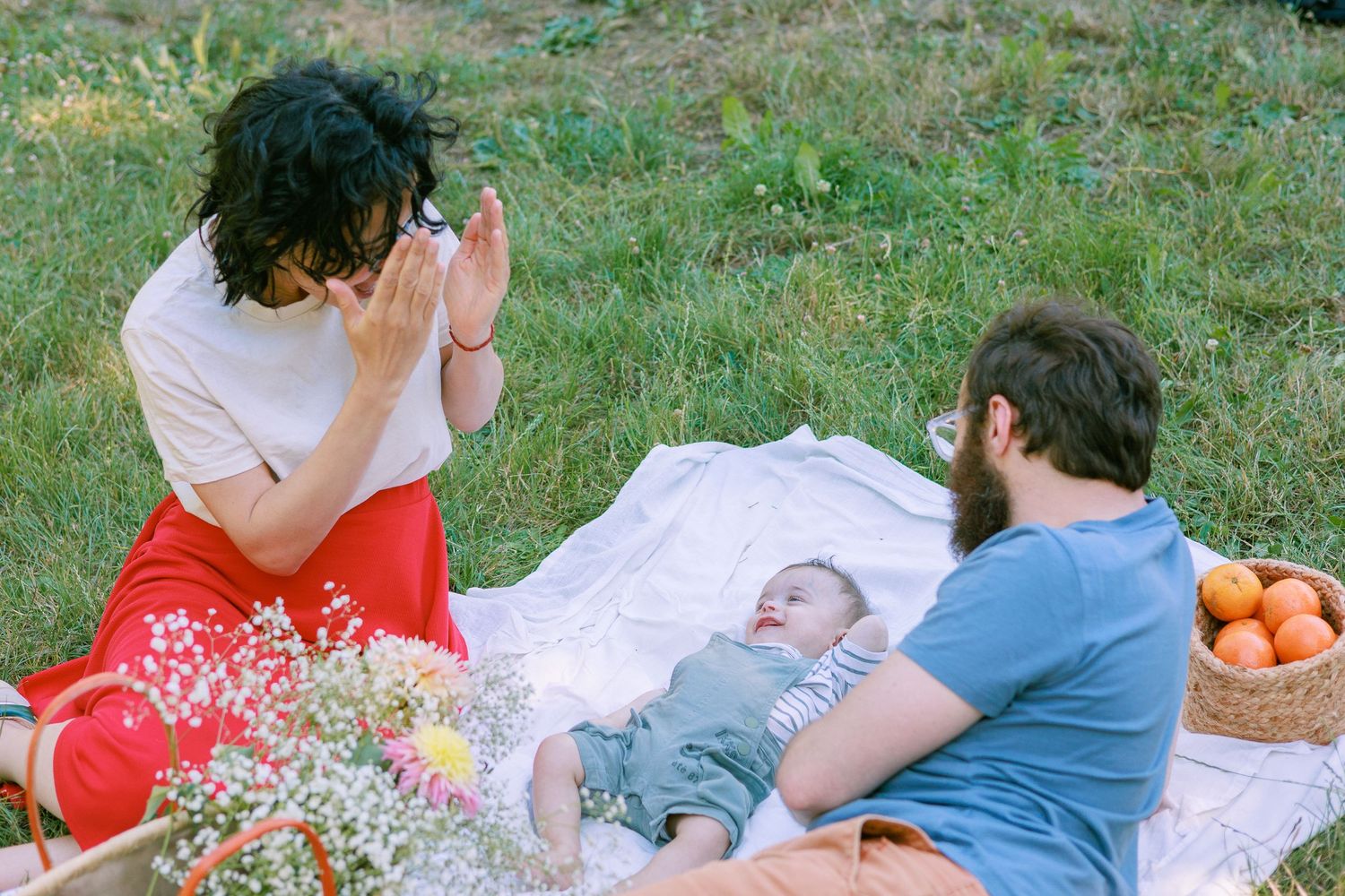 Des nouveaux parents jouent avec son bébé lors d’une séance photo en extérieur à Avignon