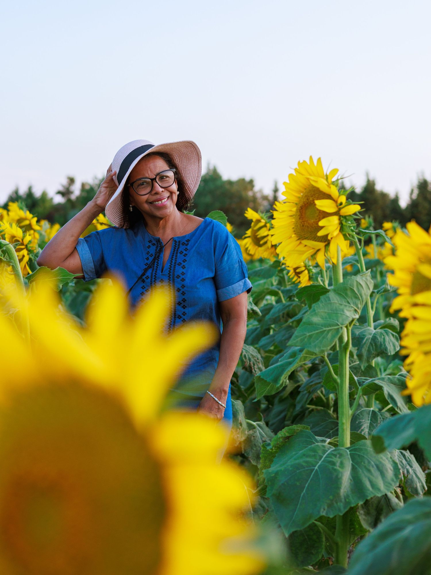 Une femme sourit au milieu d’un champ de tournesols pendant une séance photo portrait proche de Nimes