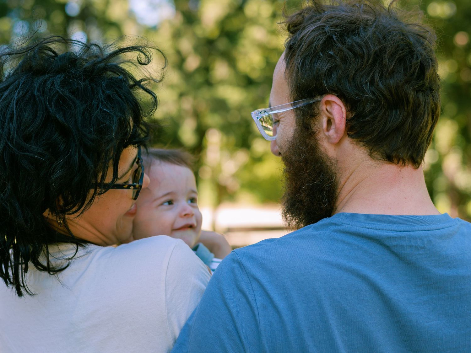 Des nouveaux parents regardent avec amour son bébé lors d’une séance photo en extérieur à Avignon