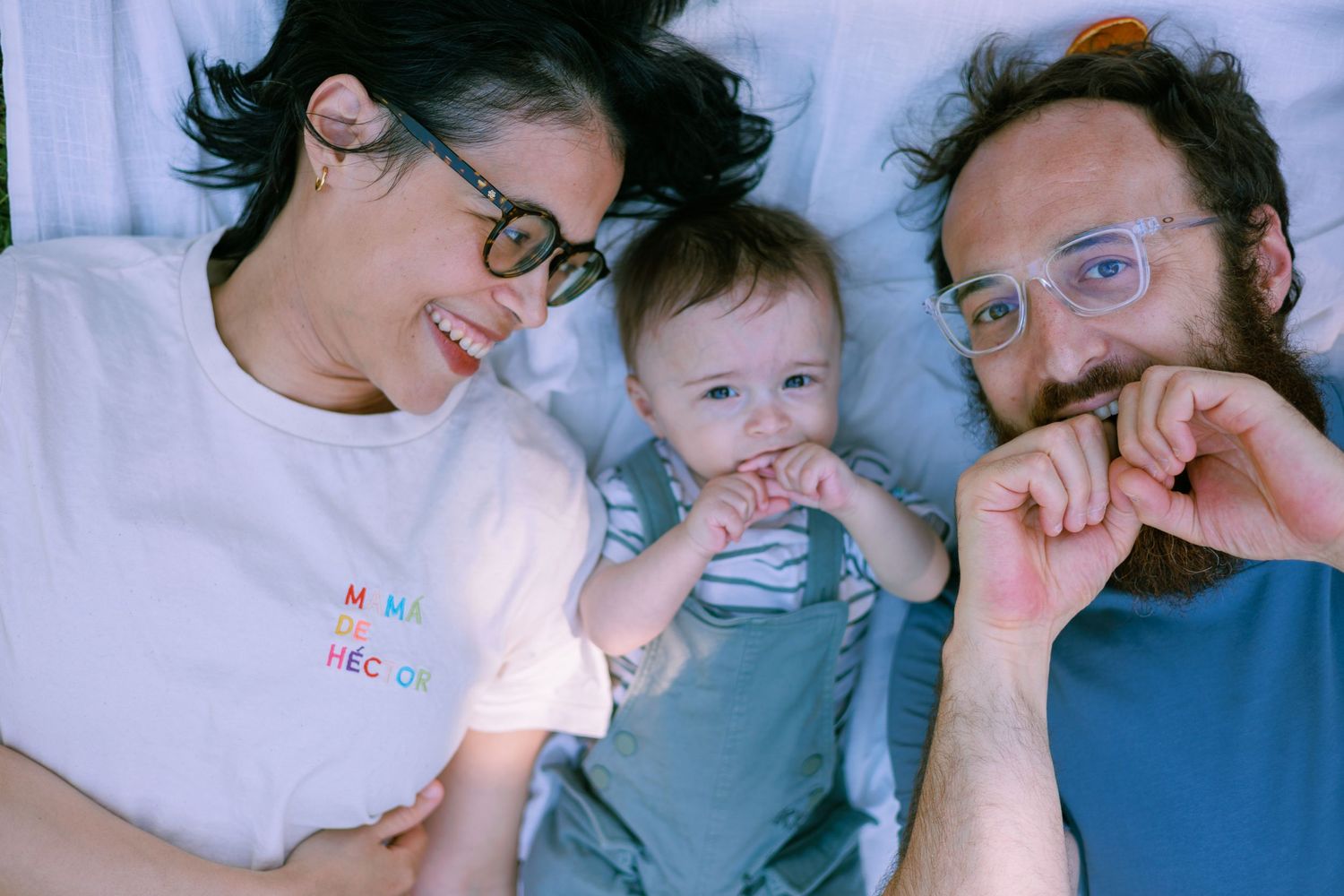 Des nouveaux parents regardent avec amour son bébé lors d’une séance photo en extérieur à Avignon