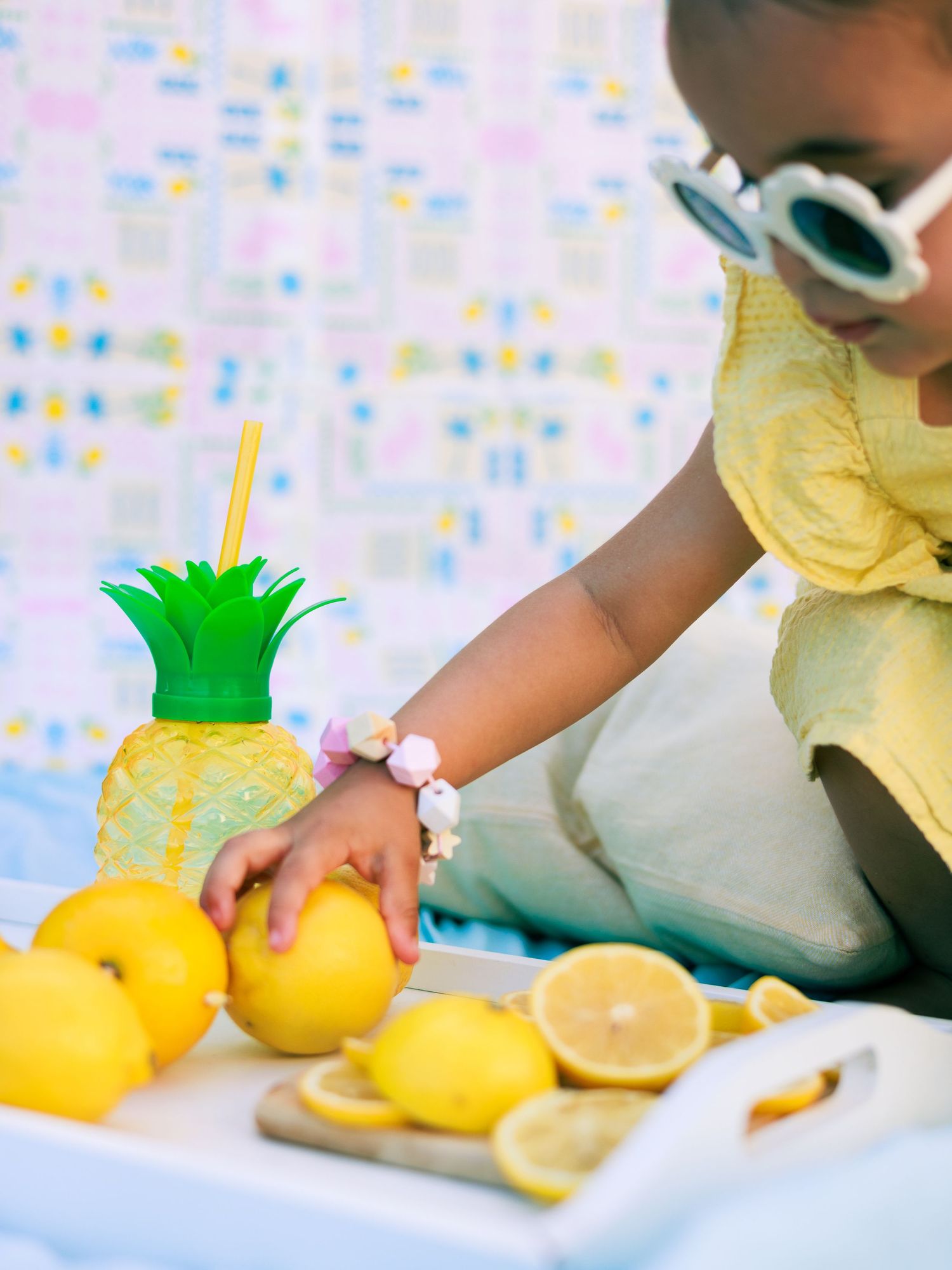 Un enfant joue avec des citrons pendant une séance photo enfant sur le thème de l’été.