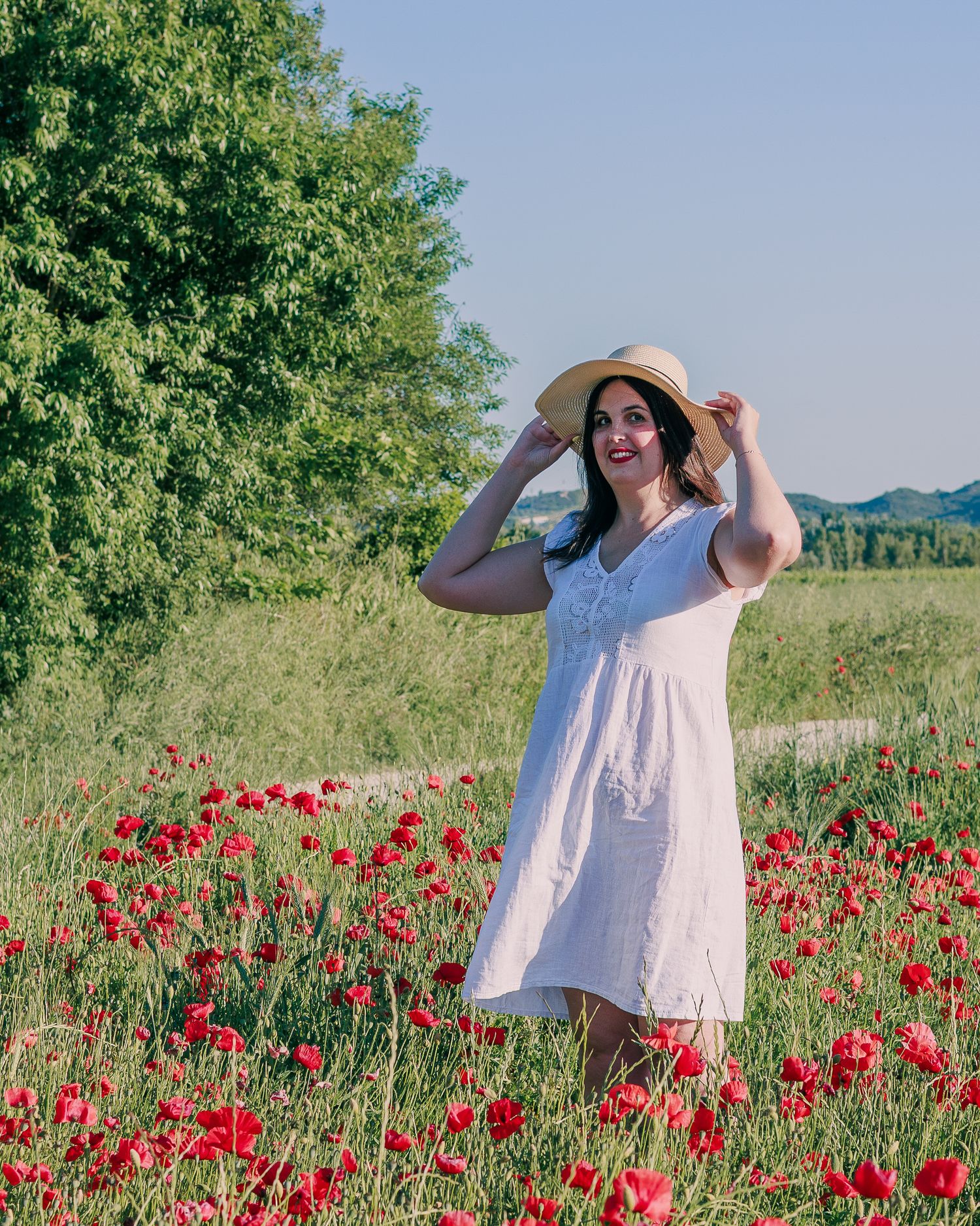 Une femme pose dans un grand champ de coquelicots en Vaucluse