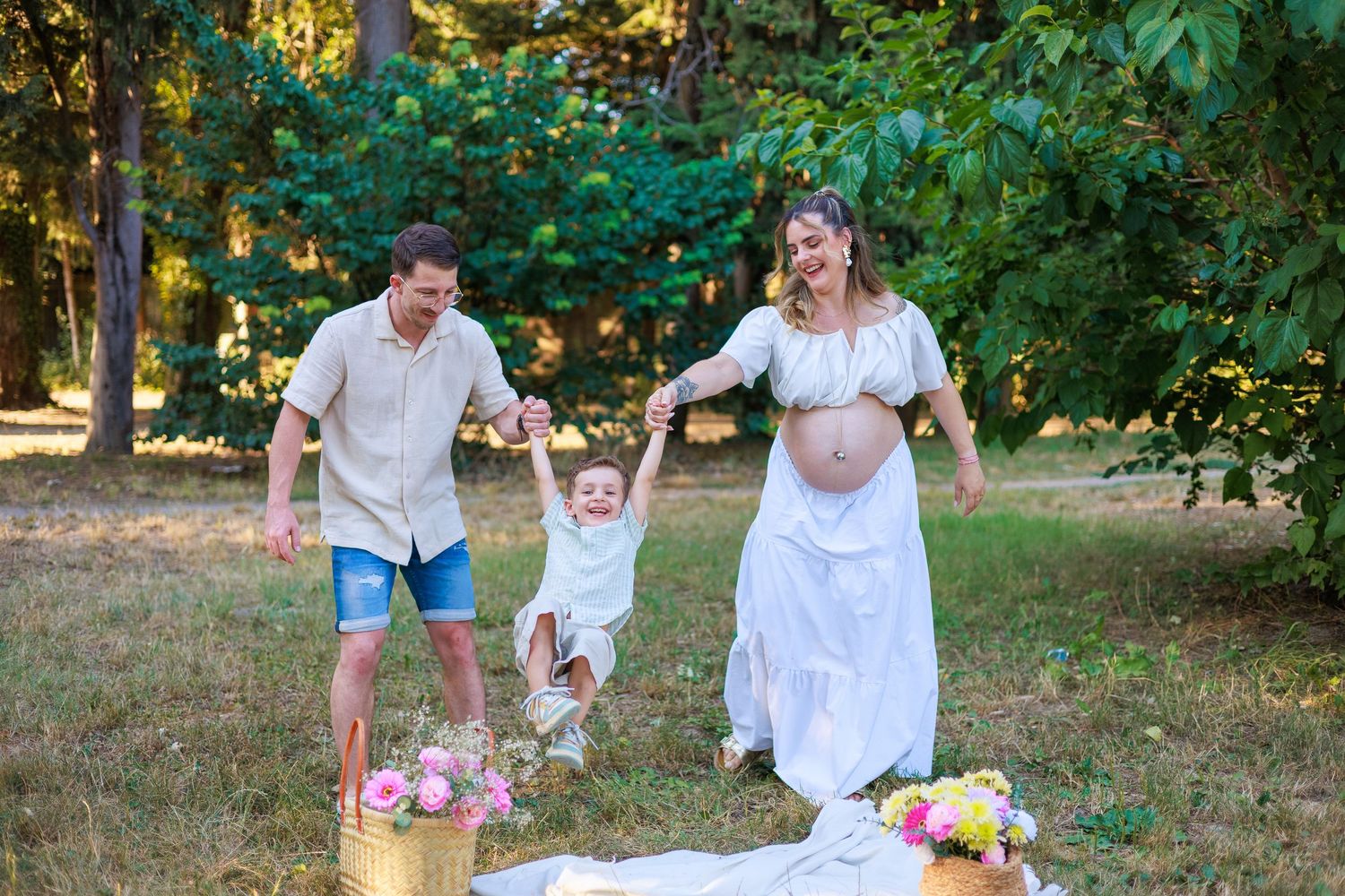 Des parents s’amusent avec leur enfant pendant une séance photo famille en extérieur.