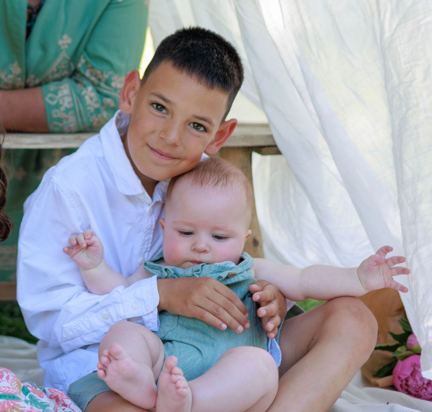 Un grand frère porte son petit frère et pose devant l’appareil photo pendant une séance photo famille.