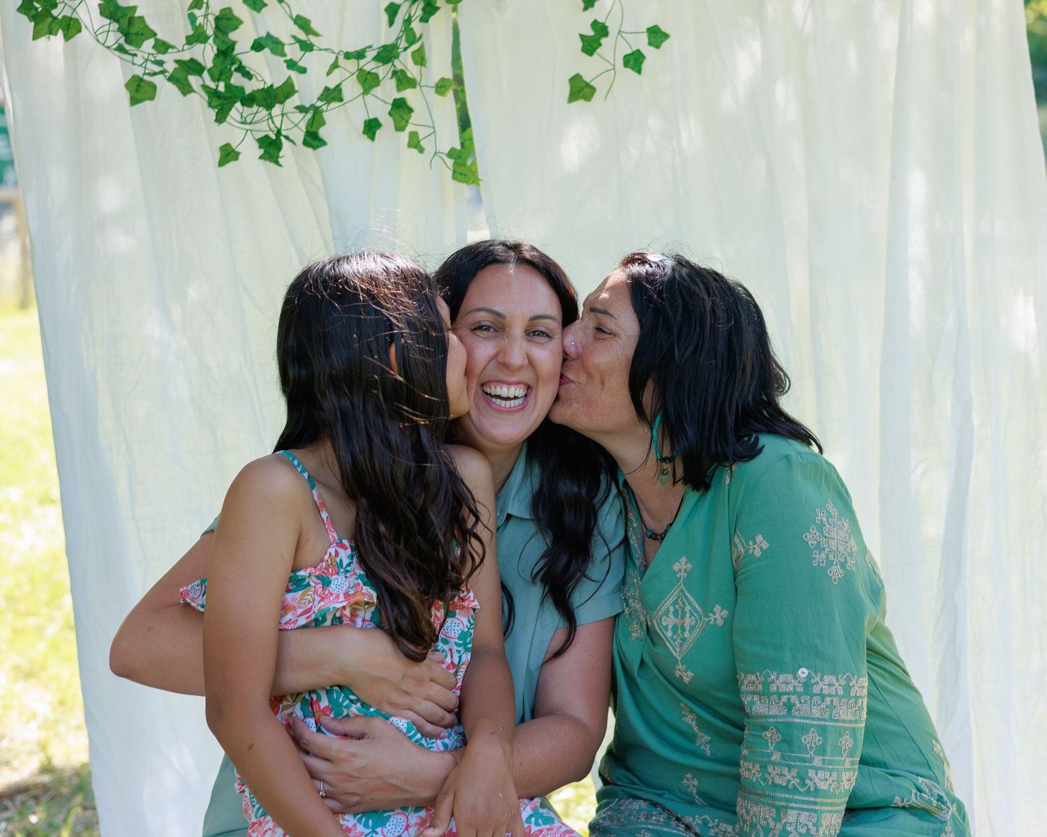 trois generations reunis la fille et la grand mere embrassent la maman pendant une séance photo famille