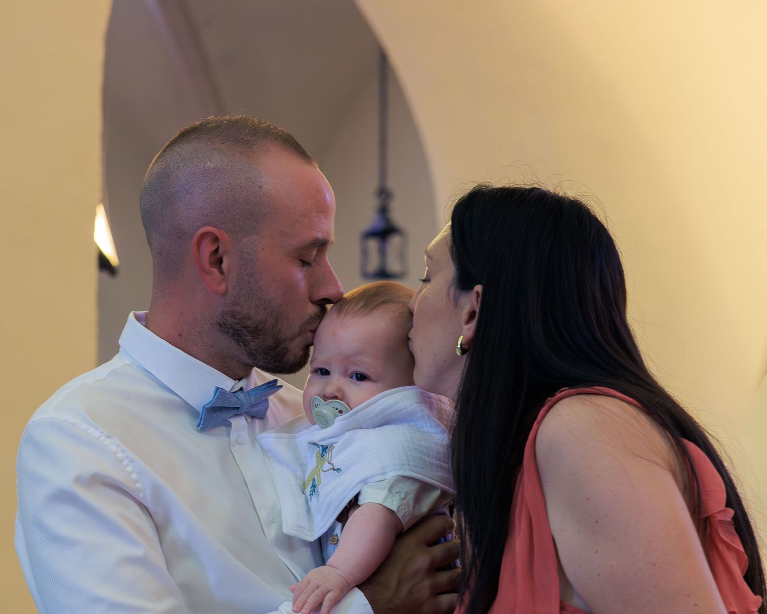 Des parents embrassent leur bébé à l’église pendant une cérémonie.