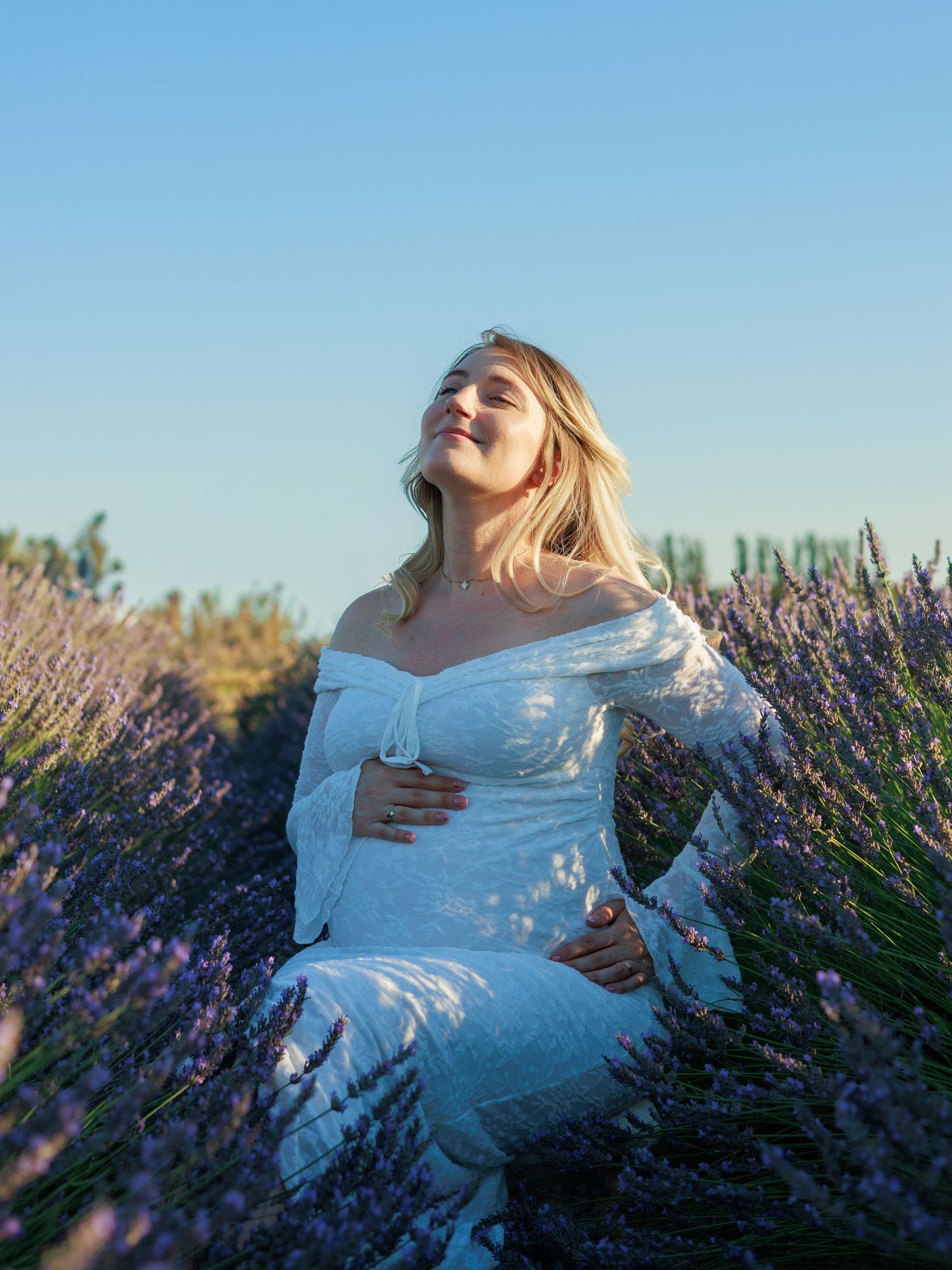 Une future maman pose dans un champ de lavande pendant une séance photo grossesse a Orange