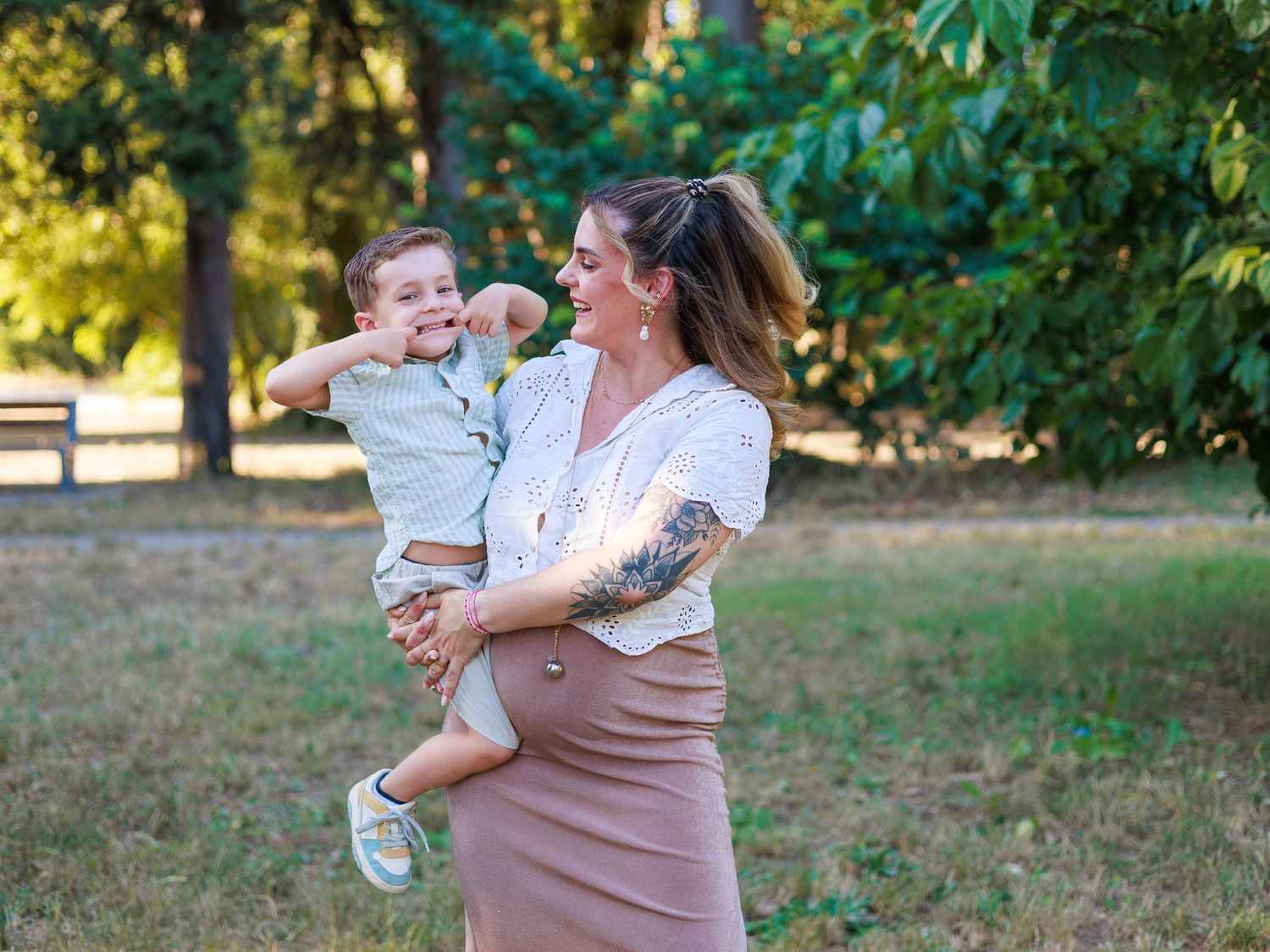 Une maman et son enfant s’amusent ensemble pendant une séance photo famille au parc