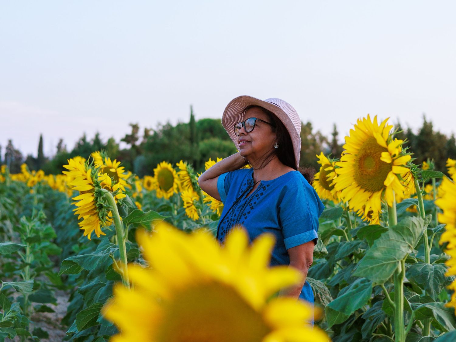Une femme pose au milieu d’un champ de tournesols pendant une séance photo portrait en extérieur dans le Gard