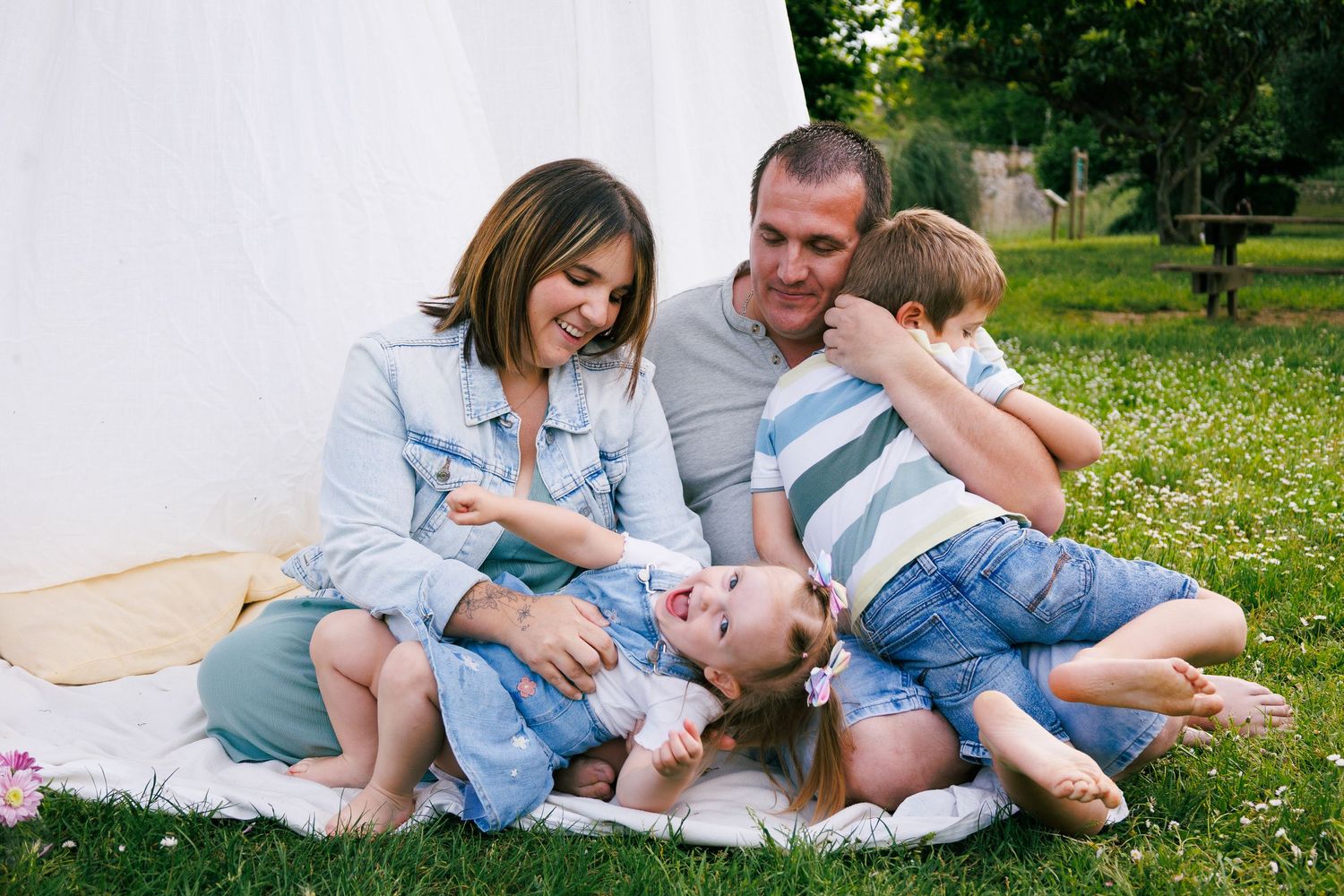 Une famille joue ensemble  pendant une séance photo famille au parc