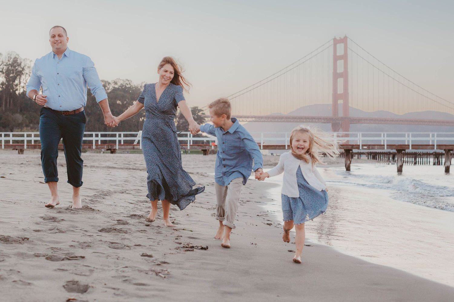 Family portrait at Crissy Field with the Golden Gate Bridge in the background.